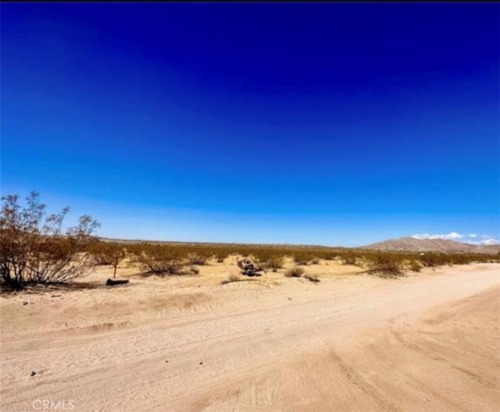 Come see these flat 3plus acres of pristine desert land about 15 minutes away from Joshua Tree National Park. The parcel is level and has panoramic views in every direction. This a great location to build your dream home and enjoy the beauty of the desert and escape the hustle of city life. The forever views of the National Park to the South, Copper Mountain to the East, Bunker Mountain to the North, and Bartlett Mountains to the West. There are very few nearby developments providing you with privacy and a rural setting while still being just a few miles away from all the amenities of a small town. Dennis Road is an unpaved dirt road. Come drive by today and imagine the possibilities. Note – do use address in GPS. The parcel is just north of the intersection of Dennis Ave and Sutton Ave. Coordinates are 34.158230, -116.288036.