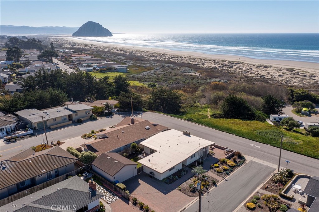 A rare Morro Bay listing! This 3 bed 3 bath OCEANFRONT Beach Tract home could just be the home you’ve been waiting for. Enjoy endless views of the Pacific Ocean from Morro Rock to Cayucos from the large picture windows in the living room, dining areas, kitchen and large front patio. The fully-enclosed, wind-protected back yard includes a BBQ and beautiful landscaping. A large master bedroom suite with a walk-in closet and en-suite bathroom with large step-in shower, double sinks and a separate toilet area. There is large 2-car garage with ample driveway parking. Beach access from this home is easy and quick – across the street, walk down the path that skirts along the state park until you reach Morro Strand State beach in a couple of minutes!
Most furniture, decoration, appliances and supplies are available for sale providing a move-in ready experience, owner to exclude personal property and selected art from the sale. This home is an active vacation rental so showings are scheduled around guest reservations. Vacation rental permit cannot be transferred to a new owner per City of Morro Bay. Heating in this home is provided by the gas fireplace equipped with a heat–efficient insert warming the kitchen and living room area along with a wall heater. Information is deemed reliable but not guaranteed. Buyers should conduct their own due diligence to verify all details. All offers must include a fully executed buyer representation agreement as required by the seller and listing agents.