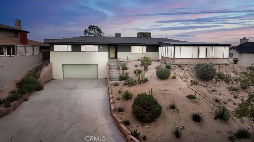 Calling all visionaries! This 3-bedroom, 2.5-bath home sits on a generous lot and offers endless potential for the right buyer. With vintage charm throughout, the home features wood-beamed ceilings, a stone fireplace, and mid-century touches waiting to be brought back to life. The kitchen showcases retro finishes, wood cabinetry, and large windows that flood the space with natural light and sweeping desert views. A spacious enclosed patio/sunroom with a pool adds valuable square footage and flexibility—perfect for future entertaining, hobbies, or a lounge area. Downstairs, the attached two-car garage includes not only additional storage space, but also a convenient powder room.  Set on a sloped lot landscaped with desert-friendly vegetation and a wide driveway, the property provides ample room for parking, gardening, or expansion. This is a great opportunity to restore a classic Barstow home with vintage character, and standout amenities. Sold as-is. Buyer to conduct their own due diligence.