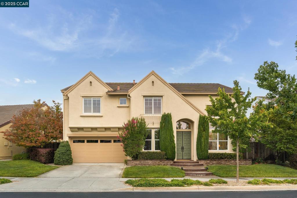 Nestled in the sought-after Bridges community, this beautifully updated home offers panoramic views of the Bridges Golf Course and Mt. Diablo. Featuring soaring ceilings, new hardwood floors, plush carpet, fresh paint, and custom light fixtures, every detail has been thoughtfully designed. The flexible floorplan includes two main-level bedrooms—one used as an office—and a full bath, ideal for guests or multi-generational living. The updated kitchen boasts new built-in appliances: microwave, cooktop, dishwasher, and double ovens. Newly painted cabinets, modern hardware, a sleek faucet, and spacious dining areas flow seamlessly into the large family room with towering windows and a floor-to-ceiling fireplace. Upstairs, the luxurious primary suite offers vaulted ceilings, a private balcony with stunning views, two walk-in closets, and a spa-inspired bath with soaking tub, walk-in shower, dual vanities, and makeup area. Three additional bedrooms and a laundry room complete the upper level. The low-maintenance backyard features patios, lawn, rose bushes, and two lemon trees—perfect for relaxing sunsets. Walking distance to the community pool, tennis court, driving range, parks, and top-rated San Ramon Valley schools.