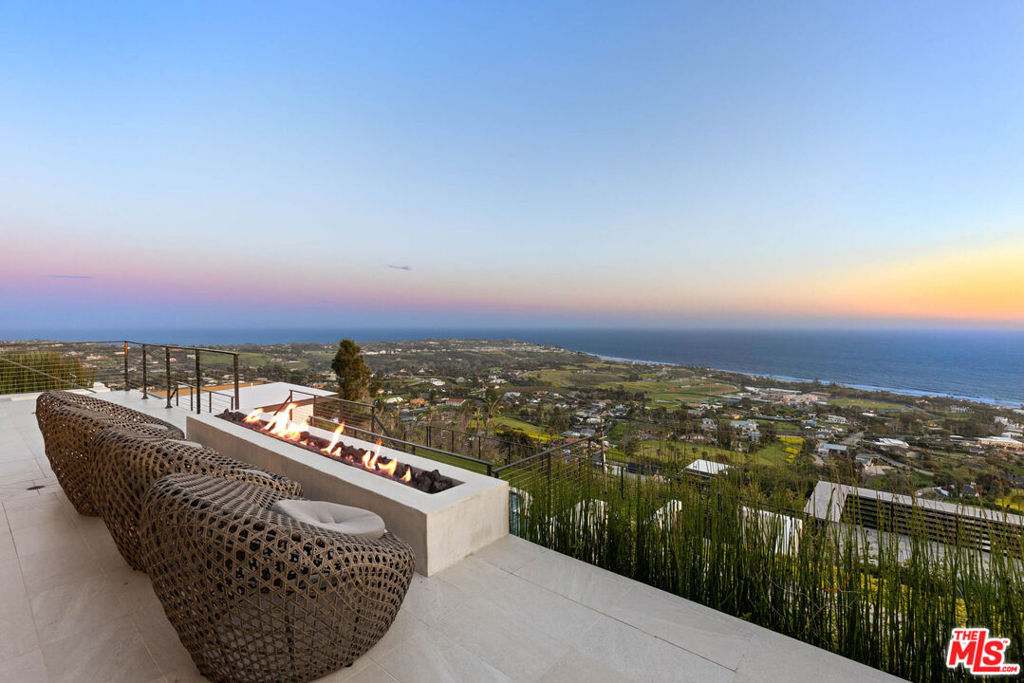 Stunning Malibu Park contemporary estate, on nearly 1.5 acres of land, ideally positioned between breathtaking panoramic white water ocean views and Riviera-like coastal mountains. Boasting nearly 6,500 square feet, the newly remodeled home features an architectural staircase anchored by white oak flooring and bespoke cabinetry, luxury upgrades and large indoor and outdoor spaces perfectly designed for entertaining. Unique stonework and honed marble offsets warm plaster walls and wood clad ceilings. This property takes full advantage of its stunning views with oversized doors and windows highlighting wraparound vistas from almost every room in the house. Outside features a large pool, spa, barbecue area, outdoor powder bathroom and multiple terraces with fire pits, dining patios, and loggia with cinematic sized screen all overlooking the Pacific ocean. Further amenities include a private & gated driveway that winds up to a large courtyard with a pair of two-car garages lending a generous amount of parking. Huge mountain-view backyard terrace, top of the line stainless steel kitchen appliances, an elevator, oversized bathroom fixtures, walk-in showers and dressing rooms and smart home features. Your dream Malibu estate awaits.
