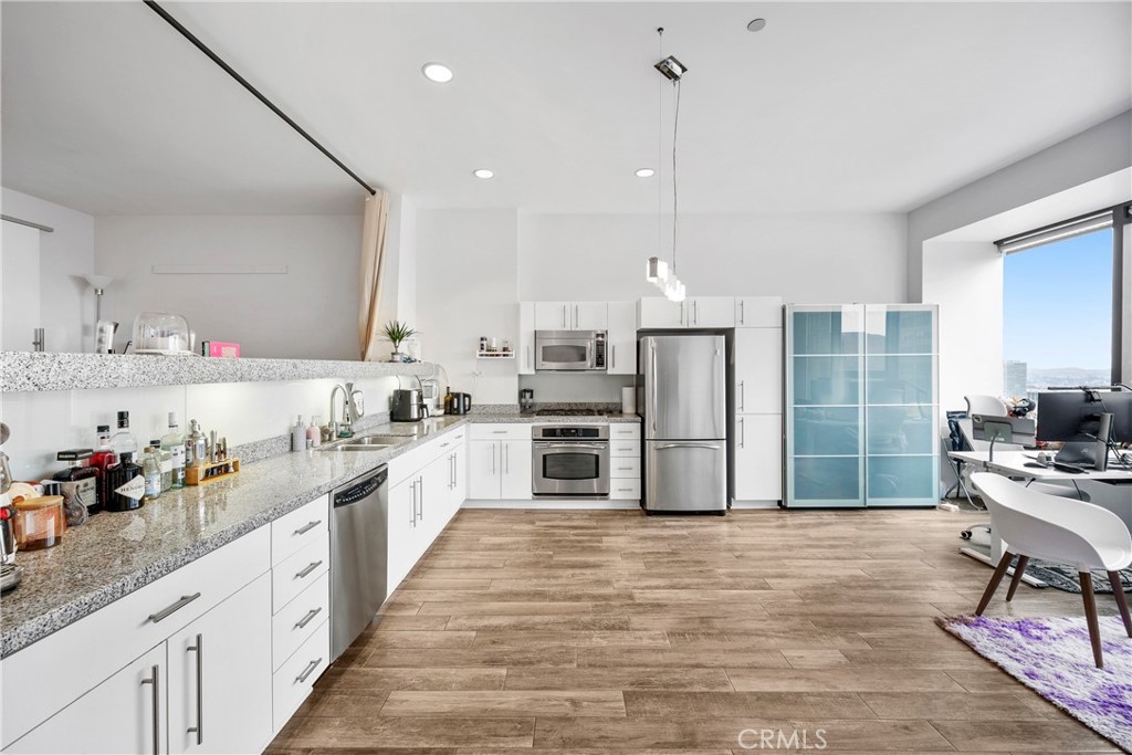 Not quite ready to move in? Even better! Here’s your opportunity to OWN a PRESTIGIOUS piece of real estate along LA’s iconic WILSHIRE BOULEVARD— and KEEP it leased out until you’re ready to make it home. Situated high on the 26th FLOOR, this PEACEFUL west-facing loft offers BREATHTAKING SUNSET VIEWS, capturing the glowing golden hour light through expansive wall-to-wall windows. The 800 sq ft layout is thoughtfully designed with an OPEN-CONCEPT living and dining area, allowing for versatile furnishing arrangements and a spacious feel. The ELEVATED PLATFORM BEDROOM includes two closets, plush carpeting, a wraparound ledge perfect for displaying art or décor, and UNOBSTRUCTED CITY VIEWS. The KITCHEN features granite countertops, stainless steel appliances, plentiful cabinet space, and recessed lighting—ideal for both daily living and entertaining. This CHARMING BATHROOM offers a nostalgic coastal vibe with sailor blue and navy tile accents. Enjoy a relaxing soak in the deep tub, a separate walk-in shower, an oversized vanity, and generous storage throughout. At 1100 WILSHIRE, you don't need to leave your building to enjoy LUXURY AMENITIES; on the 17th-floor ?SKYDECK, including a HEATED INFINITY POOL, SPA, CABANAS, LOUNGE BEDS, WET BAR, multiple BBQ area and a FIRE PIT—all designed for RELAXATION and ENTERTAINMENT. Stay fit in the fully equipped GYM with flat-screen TVs or unwind in the PRIVATE MOVIE THEATRE. A BUSINESS CENTER, GUEST PARKING, 24-HOUR CONCIERGE, and controlled access add to the convenience and SECURITY. Located just steps from the Financial District, LA Live, 7th & Fig, and some of LA’s best dining and shopping, you’re truly in the heart of it all. The HOA COVERS water, gas, and trash, making urban living seamless. Also within walking distance: Whole Foods, Perch, 71Above, Water Grill, Clifton’s, Teragram Ballroom, and more. Just a short drive to the Arts District, Echo Park, Silverlake, and Elysian Park (Dodger Stadium), with quick access to the 110, 10, and 101 freeways. Nestled among HOLLYWOOD's elite, this residence offers unparalleled ELEGANCE and EXCLUSIVITY. Don't miss your chance to be part of this LEGENDARY locale.