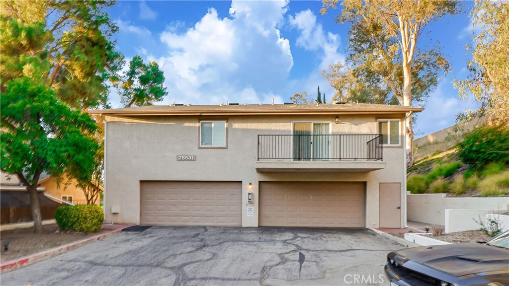 Welcome to this charming Murrieta Villas condominium! With two bedrooms and two bathrooms, this lovely upstairs unit boasts 993 square feet of living space, a private front-facing balcony and an attached garage. The entryway welcomes you at ground level, where a staircase leads to the main living area on the second floor. At the top of the stairs, natural light fills the living room from the sliding glass door to the private balcony, highlighting the combination of carpet and tile flooring and the light, neutral paint scheme throughout. Beyond the living area, the well-appointed kitchen, dining space, bedrooms and bathrooms await. The kitchen offers ample counter and cabinet space, along with a convenient in-kitchen laundry area. You will also find a 5 burner electric stove and oven, dishwasher, built-in microwave, and a window over the sink that fills the space with natural light. Down the hallway, you will find a spacious walk-in closet with built-in shelving for easy organization. The hallway bathroom features a shower/tub combination, tile flooring, and a single sink vanity. The master bedroom is complete with plush carpeting, a closet with three sliding doors, a ceiling fan for comfort, and a window that bathes the room in natural light. The attached master bathroom boasts tile flooring, single sink with a vanity sitting area, and a shower/tub combination. Equally welcoming, the additional bedroom has plush carpet flooring, a closet, a ceiling fan, and a window. Conveniently located, this home provides easy access to shopping centers, freeways, and highways, striking a harmonious balance between comfort and accessibility.