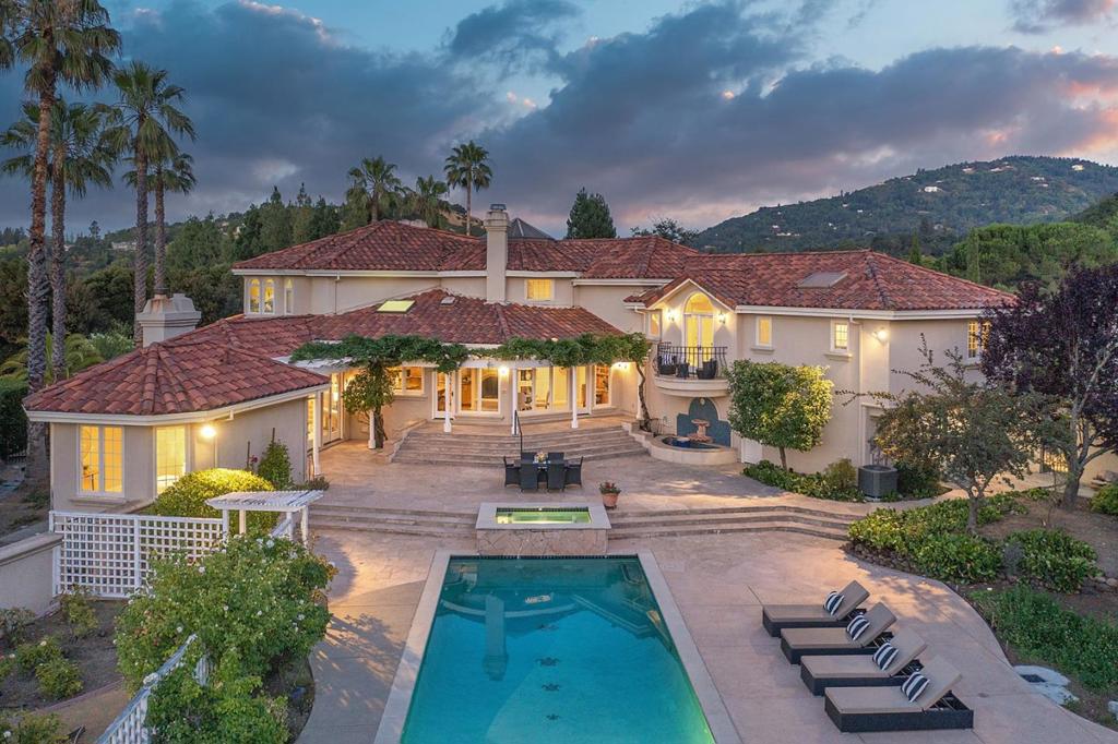 Custom Conrado-built estate located at the end of a cul-de-sac in a prime Saratoga location. This thoughtfully designed residence blends craftsmanship and function throughout. Highlights include a formal living room with handcrafted limestone fireplace, formal dining room, family room with a bespoke second fireplace and wet bar, and a gourmet kitchen featuring two Viking ovens, Sub-Zero fridge, Gaggenau cooktop, two dishwashers, and three sinks. Breakfast room with fireplace. Additional features include hand-forged kitchen hardware, walk-in pantry, guest suite with sauna, cherry wood office, and a concealed 100-bottle wine drawer. Upstairs primary suite includes a balcony, fireplace, spa bath, and in-suite washer/dryer. The private, solar-heated 54-foot lap pool is complemented by a spa, expansive patios, vegetable beds, and dining terrace across a charming bridge. Zoned HVAC, speaker system, and a 3-car garage with built-ins. Minutes to downtown Saratoga, top schools, and commuter routes.