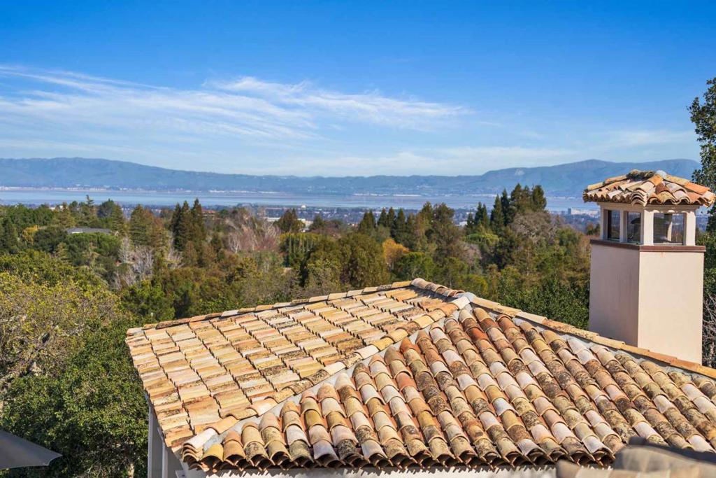 OLD WORLD CHARACTER, CUTTING-EDGE FLAIR | Perched amidst hilltop grounds with panoramic San Francisco Bay views, this masterpiece completed in 2020 integrates the warmth, beauty, and history of the South of France with state-of-the-art luxuries. Never occupied, the home abounds with indoor-outdoor spaces fashioned for unforgettable living. A collection of gathering areas opens to terraced gardens with fire and water features, an outdoor living room, and entertaining pavilion with kitchen. Every bedroom enjoys its own bathroom and climate controls. Downstairs await a gym, wine cellar, billiard room, and home theater with wet bar. Exceptional details include 300-year-old roof tiles from Spain, Belgian oak finishes, Spanish olive trees, Sonos sound, and a contemporary chef's kitchen of Calacatta marble & European appliances. Stroll to scenic Byrne Preserve. Within minutes of Palo Alto Hills Country Club, downtown Los Altos, Palo Alto schools (buyer to verify). Furnishings are negotiable.