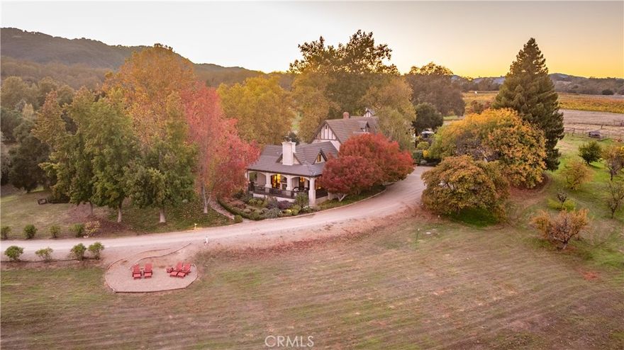 There is a place, tucked among the rolling hills of Paso Robles Wine Country, where time slows and the air carries the soft perfume of oak and vine. This magical estate, set on approx. 38.2 gently sweeping acres along coveted Vineyard Drive, is a haven of warmth, charm, and grace.

The main residence, resting gracefully among the trees, radiates timeless character and sophistication. Inside, every detail has been thoughtfully crafted — three spacious bedrooms, three full baths, one three-quarter bath, and one half bath designed for comfort and ease.

The kitchen is a gathering place, featuring a cozy breakfast nook with a Dutch door opening to the sunlit backyard and multiple seating areas. A formal dining room invites evenings of conversation, while the family room with a spectacular indoor/outdoor stone fireplace and multiple double doors spills onto a wraparound porch overlooking vineyards, oak groves, and rolling hills.

Nearby, the Carriage House mirrors the Main Home’s craftsmanship. Upstairs offers open-concept living, balconies with stunning views, a kitchen, two bedrooms, and two bathrooms, while below provides an office, hobby room, and workshop. With a B&B License, the Carriage Home is both opportunity and invitation — to host, share, and live fully.

Every window frames rolling hills, manicured gardens, and golden sunsets. On the porch, evenings pass beneath stars, the stillness broken only by crickets and a whispering breeze.

In the heart of Paso Robles Wine Country, life takes on a slower, sweeter rhythm. Mornings bring the scent of lavender and distant quail; evenings, a glass of local wine and lantern glow. This is more than a home — it is a story of beauty, serenity, and timeless California spirit.