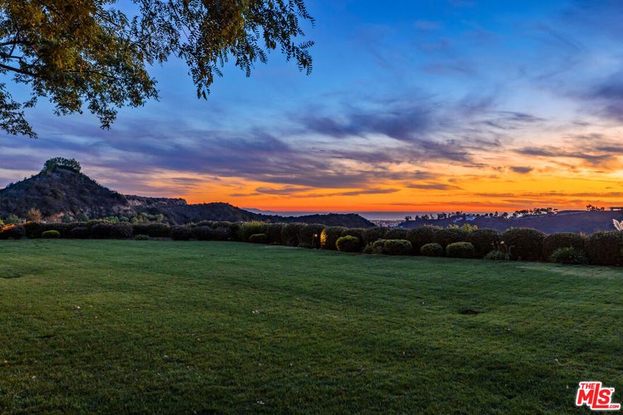 World-Class Mediterranean Villa situated on over 3.1 acres in the ultra-exclusive 24-hour guard-gated community of Beverly Ridge. Perched on a promontory accessed via a long, private drive, this one-of-a-kind estate offers grand scale living with elegant proportions and holds infinite possibilities for entertaining and amazing year-round indoor-outdoor living. As you enter, be greeted by a grand two-story foyer and a sweeping double staircase. The home has been designed to maximize natural light and features a large living room with bar, office, gourmet kitchen, breakfast room, family room, luxurious dining room with walk-in wine display/cellar, and private theater. There is also an apx. 3,600 sq.ft. subterranean garage offering parking for seven cars, an informal gym/playroom, an elevator, and two maid's rooms. The primary suite boasts spa-like dual bathrooms, vast walk-in closets, and two private office suites. All guest bedrooms are en-suite, with beautiful baths and closets, and offer stunning views. Warming floors complete all the stone bathrooms upstairs. The fabulous gourmet kitchen features two refrigerators, a built-in coffee maker, a steam oven and multi-use microwave, four ovens, two dishwashers and a warming drawer. All water is potable. The park-like grounds are complemented by a sprawling covered patio, outdoor fire pit, glamorous pool and spa, and breathtaking 360 views that span all the way from the mountains to the ocean.