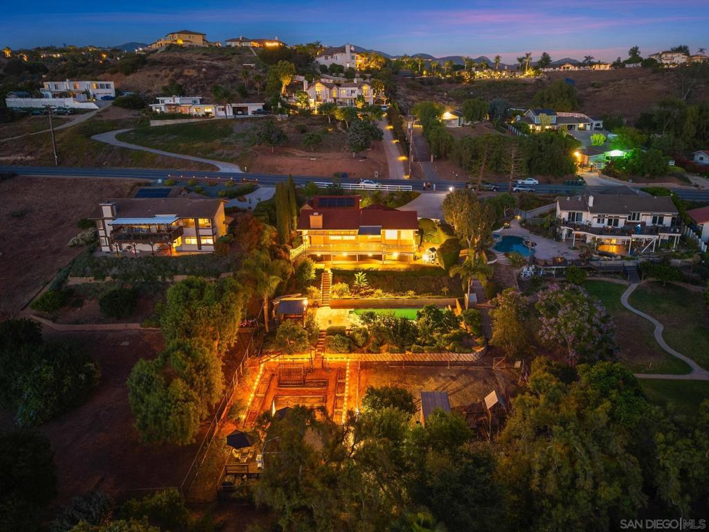 Welcome to your own hill-top hideaway—where country serenity meets city convenience and every sunset steals the show. Designed with a reverse floor plan, the main living spaces sit upstairs to maximize sweeping, west-facing views over the treetops and out toward the evening skies. Vaulted ceilings, walls of windows, and an airy, open flow connect the living room, formal dining room, and a granite counter kitchen with a center island. The adjacent family room with its cozy fireplace spills onto a massive second-story deck, creating the ultimate indoor-outdoor hub for entertaining. Energy-savvy upgrades keep costs low and comfort high: an owned 7.85 kW solar array (24 panels), a 50-amp EV charging outlet, and a new main electrical panel installed in 2018—delivering most years with an annual energy credit. Dual-pane windows and ceiling fans further boost efficiency. Downstairs, the expansive primary retreat feels like a private spa, featuring a walk-in closet, glass-block walk-in shower, and relaxing jetted tub. Three additional bedrooms provide flexible space for guests or a home office. Step outside to your personal resort: pool surrounded by two lower-level patios, towering upper deck perfect for sunset lounging. Green thumbs and animal lovers will swoon over the large, drip-irrigated garden, surrounded by 28 mature array of fruit trees, a secure chicken coop with outdoor run and a goat pen complete w/ shelter and play structure. Abundant parking for cars and recreational toys. Quiet area close to Old Poway, walking distance to the farmer's market, shopping, and more. Welcome to your own hill-top hideaway—where country serenity meets city convenience and every sunset steals the show. Designed with a reverse floor plan, the main living spaces sit upstairs to maximize sweeping, west-facing views over the treetops and out toward fiery evening skies. Vaulted ceilings, walls of windows, and an airy, open flow connect the living room, formal dining room, and a granite-clad chef’s kitchen with oversized center island. The adjacent family room—with its cozy fireplace—spills onto a massive second-story deck (mostly rebuilt 2024), creating the ultimate indoor-outdoor hub for entertaining. Energy-savvy upgrades keep costs low and comfort high: an owned 7.85 kW solar array (24 panels), a 50-amp EV charging outlet, and a new main electrical panel installed in 2018—delivering most years with an annual energy credit. Dual-pane windows and ceiling fans further boost efficiency. Downstairs, the expansive primary retreat feels like a private spa, featuring a walk-in closet, glass-block walk-in shower, and relaxing jetted tub. Three additional oversized bedrooms provide flexible space for family, guests, or a home office. Step outside to your personal resort: • Upgraded pool (2019) surrounded by two lower-level patios • Towering upper deck perfect for sunset lounging • Rebuilt front walkway (2024) for a grand welcome Green thumbs (and animal lovers) will swoon over the large, drip-irrigated garden, an orchard of 28 mature fruit trees (apple, peach, avocado, citrus, fig, cherry, and more), a secure chicken coop with outdoor run, and a roomy goat pen complete with shelter and play structure—truly “country living in the city.” With abundant parking for guests, RVs, or recreational toys, plus thoughtful modern upgrades throughout, this light-filled retreat delivers the best of all worlds: stunning views, sustainable living, and acres of outdoor joy—ready for you to move in and start making memories.