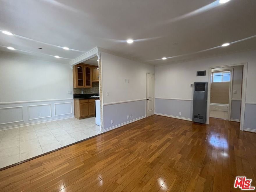 Discover charming West Hollywood living in this spacious upper-level 1-bedroom, 1-bathroom apartment. Located in a well-maintained 8-unit building, this unit provides a peaceful retreat while placing you just moments from the best shops, cafes, and everyday conveniences the neighborhood is known for. Inside, the unit features real hardwood flooring, elegant crown moulding, and beautiful wainscoting throughout, creating a warm and refined atmosphere. The generous living area flows into a well-appointed kitchen and dining area, equipped with stainless steel appliances, including a refrigerator and range with hood, plus a microwave and garbage disposal. The bedroom includes a large cedar-lined closet and an air-conditioning unit for personalized comfort. The bathroom is clean, bright, and updated with contemporary fixtures. Water and trash are included in the rent. One parking space is available for an additional fee. With a Walk Score of 95, this prime location places you moments from Trader Joe's, Sprouts, Target, Starbucks, and the countless dining and entertainment options West Hollywood has to offer. Easy access to public transportation makes commuting throughout Los Angeles simple and convenient.