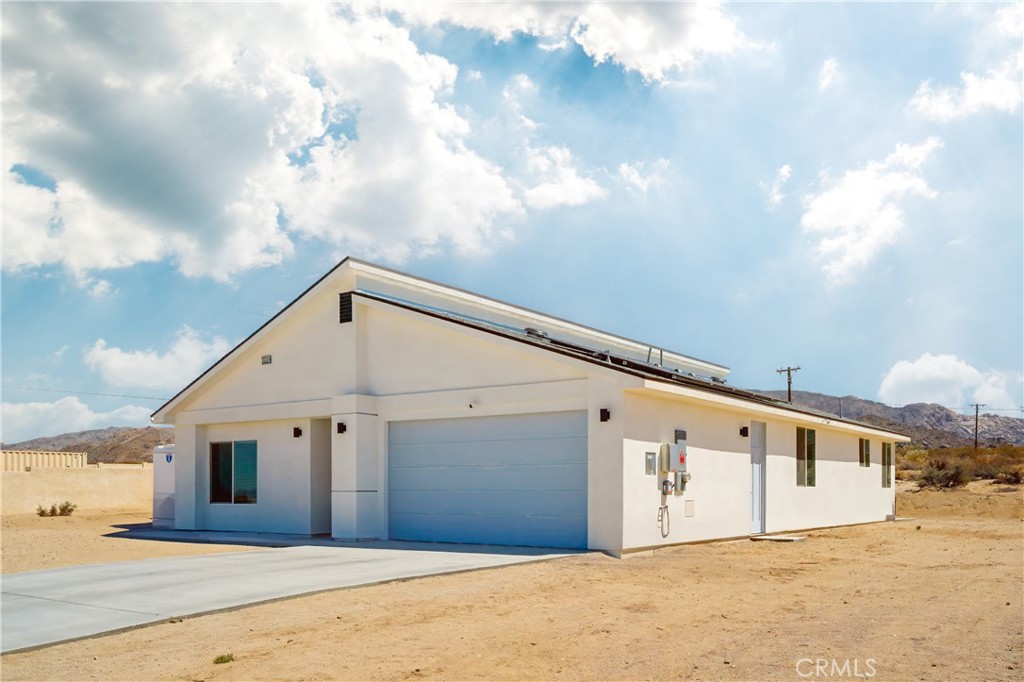 Let the Sun Shine! Modern Retreat in Indian Cove, 29 Palms This stunning 2023-built, 1,857 sq ft contemporary home in Indian Cove, 29 Palms, boasts 4 beds and 3 baths on a 1.1-acre lot with a modern split-level roof design that redefines possible. Step inside to dramatic high ceilings, sleek laminate flooring, and recessed lighting and natural light that flows and enhances the airy ambiance. The home is replete with energy-efficient windows and doors meeting California’s 2020 Title 24 standards. What else? Fully PAID OFF SOLAR SYSTEM to keep utility costs low, paired with enhanced insulation and fire suppression sprinklers to possibly lower the insurance bill and give peace of mind. The open-concept living room and kitchen blend modern design with warmth and comfort. The gourmet kitchen features modern appliances, quartz countertops, ample cabinetry, and a spacious pantry, ideal for entertaining. Bathrooms exude elegance with sleek fixtures and a spa-like serenity while the bedrooms are sunlit sanctuaries with large windows framing dramatic desert views. And what views we have in Indian Cove! Sunlight provides a daily light show both morning and evening. Ample closets and a two-car garage provide storage. This home is Impeccably maintained, with those high ceilings, recessed lighting, quartz countertops and a feeling of elegance, this is the finest home in 29 Palms on the market today. The lovely Indian Cove neighborhood is just 10 minutes from downtown 29 Palms shopping, 15 minutes to the USMC base, 15 minutes to the entrance of Joshua tree National Park and just an hour to the urban amenities found in Palm Springs. And there are hiking trails right in this neighborhood. 29 Palms is growing and the area offers outdoor adventures and cultural vibrancy and continues to be a destination from big cities. This beautiful home would be perfect as a primary residence, weekend getaway, or a solid investment—let the sun shine on your new chapter!