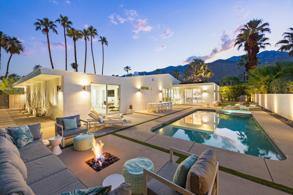 Reimagined and fully updated midcentury home in Palm Springs' iconic Twin Palms! This is one of the best and most sought after neighborhoods of Palm Springs, known for its architecture, its proximity to town and its resort vibes. Walled and gated for maximum privacy, this 4-bedroom home offers 2,824 sq ft of open, light-filled living. Soaring ceilings, oversized rooms, and a dramatic floor-to-ceiling fireplace set the tone, while the chef's kitchen showcases luxurious finishes--a waterfall-edge island, gorgeous tilework, and large-format flooring that carries through the living spaces.Designed for connection and flow, this home features sliding glass to outdoor spaces on all sides and from every bedroom suite. A welcoming courtyard with a fire-pit leads to a grand front entry, a stunning first impression; the backyard features a sparkling Pebble-Tec pool, outdoor shower, a second fire pit near the pool, and generous lounging area which create the feeling of a very private resort--with views of Mt San Jacinto. The spacious primary suite includes dual walk-in closets and a spa-inspired bath with soaking tub, walk-in shower, and dual vanities. Sustainability is built in with 58 owned solar panels that cover nearly all energy needs. With a proven track record as a luxury vacation rental, this home is equally suited for entertaining, investment, or full-time desert living. A quintessential Palm Springs retreat in one of the best neighborhoods of Palm Springs.