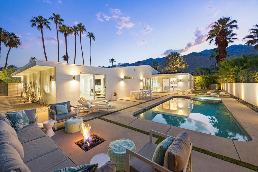 Reimagined and fully updated midcentury home in Palm Springs' iconic Twin Palms! This is one of the best and most sought after neighborhoods of Palm Springs, known for its architecture, its proximity to town and its resort vibes. Walled and gated for maximum privacy, this 4-bedroom home offers 2,824 sq ft of open, light-filled living. Soaring ceilings, oversized rooms, and a dramatic floor-to-ceiling fireplace set the tone, while the chef's kitchen showcases luxurious finishes--a waterfall-edge island, gorgeous tilework, and large-format flooring that carries through the living spaces.Designed for connection and flow, this home features sliding glass to outdoor spaces on all sides and from every bedroom suite. A welcoming courtyard with a fire-pit leads to a grand front entry, a stunning first impression; the backyard features a sparkling Pebble-Tec pool, outdoor shower, a second fire pit near the pool, and generous lounging area which create the feeling of a very private resort--with views of Mt San Jacinto. The spacious primary suite includes dual walk-in closets and a spa-inspired bath with soaking tub, walk-in shower, and dual vanities. Sustainability is built in with 58 owned solar panels that cover nearly all energy needs. With a proven track record as a luxury vacation rental, this home is equally suited for entertaining, investment, or full-time desert living. A quintessential Palm Springs retreat in one of the best neighborhoods of Palm Springs.
