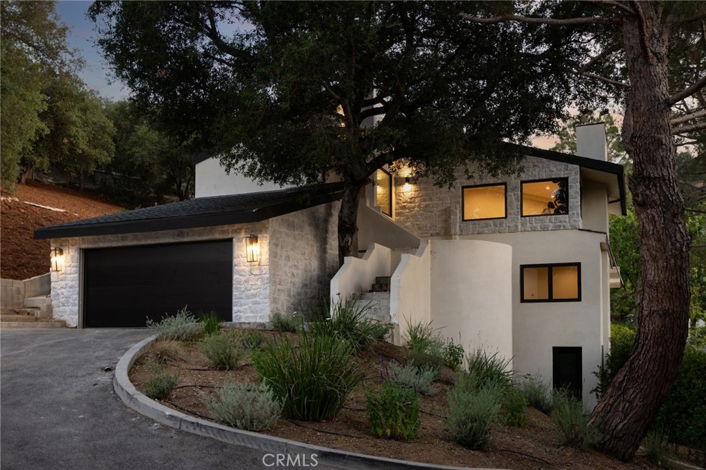 Privately gated and tucked away at the end of a quiet cul-de-sac in Studio City’s desirable “Silver Triangle,” this beautifully remodeled two-story home offers the perfect blend of style, comfort, and privacy. Surrounded by mature trees and lush landscaping, the 5-bedroom, 5-bathroom residence feels like a peaceful retreat while still being just moments from Ventura Boulevard’s shops, restaurants, and studios.
Completely remodeled down to the studs, the home has been thoughtfully transformed with wide-plank wood flooring, custom cabinetry, and high-end finishes throughout. Bright, open spaces with vaulted ceilings and large windows fill the home with natural light and a welcoming atmosphere.
The living room features dramatic ceiling heights and an airy layout, creating an ideal space to relax or entertain. The chef’s kitchen is equipped with top-of-the-line appliances and an oversized center island, offering generous counter space and storage. It flows seamlessly into the family room with a fireplace and sliding doors that open to a quiet deck—perfect for indoor-outdoor living.
All five bedrooms include en-suite bathrooms, offering comfort and privacy for every resident or guest. The spacious primary suite serves as a private retreat, complete with luxury finishes and spa-like amenities.
A versatile bonus space adds even more value—ideal for use as a home office, gym, creative studio, or future ADU, giving flexibility for evolving needs.