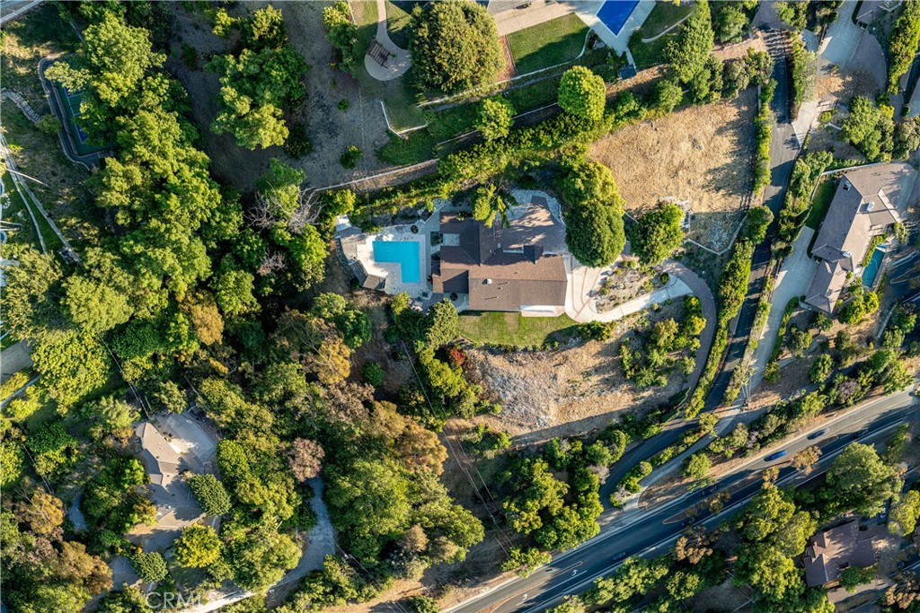 Elevated luxury meets contemporary aesthetic in the prestigious City of Rolling Hills, this newly remodeled estate captures the sweeping unobstructed views of the glittering Los Angeles city lights, on a sprawling 2.4 acres of pristine land. A extensive renovation completed in 2024 showcases meticulous craftsmanship and top-tier finishes throughout. The expansive open concept living area flows seamlessly onto a sprawling view terrace through oversized corrugated glass doors, framing the city skyline and inviting indoor-outdoor living at its finest. The state-of-the-art chef’s kitchen is a statement of form and function, anchored by a dramatic waterfall-edge island and outfitted with premium Sub-Zero and Wolf appliances, a 60-inch double oven range, steam oven, built-in coffee system, and custom cabinetry designed with precision and elegance.
The grounds have been thoughtfully landscaped to create a resort-like retreat, with multiple tranquil garden vignettes, a secluded pool area designed for both privacy and entertainment, and a flourishing orchard with mature apple, pear, orange, fig, and avocado trees. At the rear of the property, a rare barn opens up endless possibilities for equestrian use, hobby farming, or further expansion, with direct access to miles of private horse trails to the Rolling Hills community.
Additional highlights include an oversized three-car garage, a stately circular driveway with generous guest parking, and proximity to nationally ranked public schools in the Palos Verdes Peninsula Unified School District, as well as prestigious private institutions such as Chadwick School and Rolling Hills Country Day.
This rare offering is more than a residence—it is a private sanctuary that embodies the pinnacle of luxury, lifestyle, and land. Perfect for those seeking a harmonious blend of sophisticated living, panoramic views, and equestrian charm in an ultra-exclusive setting.