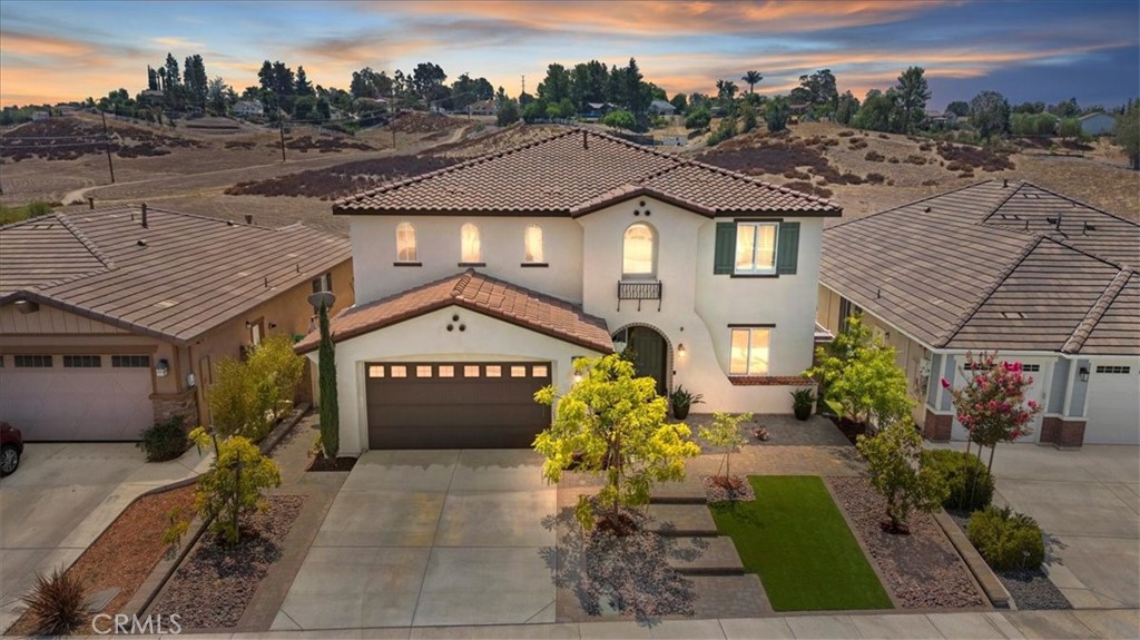 Welcome to this stunning home located in the highly desirable gated community of Nicolas Heights—a small, private enclave in the heart of Temecula offering both privacy and peace of mind. Built in 2019, this 3,648 sq ft residence showcases a sleek, modern layout and exceptional designer upgrades throughout, all set on a premium view lot with no rear neighbors and panoramic scenery that enhances everyday living. The curb appeal is undeniable, with wrought iron accents and fully finished front and back yards featuring eye-catching brick pavers and lush landscaping. Inside, you'll find a light-filled open floorplan with elegant tile and wood flooring, plantation shutters, and brand new interior paint that gives the home a fresh, updated finish. The inviting kitchen is a showstopper, boasting a large quartz island, detailed stone backsplash, pendant lighting, GE Profile stainless steel appliances, a 5-burner stove, double oven, walk-in pantry, and Samsung refrigerator that stays. A butler’s pantry adds extra storage and convenience for hosting. The open-concept family room includes a custom fireplace, and a downstairs bedroom with full bath provides ideal flexibility for guests or multi-generational living. Wrought iron staircase railings lead to the second floor, where a spacious upstairs loft-style second living area offers plenty of room to relax, entertain, or create your ideal flex space. Three additional upstairs bedrooms are generously sized, and the secondary bathroom feature modern styling. The luxurious primary suite includes a large walk-in closet, dual sinks, vanity area, and sliding doors that open to a private balcony with wrought iron railing, where you can soak in the incredible views and peaceful ambiance. Step outside to your own backyard paradise—featuring a massive patio cover, raised fire pit seating area, a fun, low-maintenance putting green perfect for friendly competitions or practicing your short game, and a wrought iron view fence that frames the serene natural backdrop. Numerous potted plants also stay. Additional features include a 3-car garage with epoxy flooring and built-in cabinets, solar panels, washer and dryer included, and furniture and decor negotiable—a perfect opportunity for a turnkey purchase. This is a rare chance to own a luxurious, newer home with spectacular views in one of Temecula’s most exclusive gated communities—just minutes from top-rated schools, shopping, dining, and award-winning wineries.