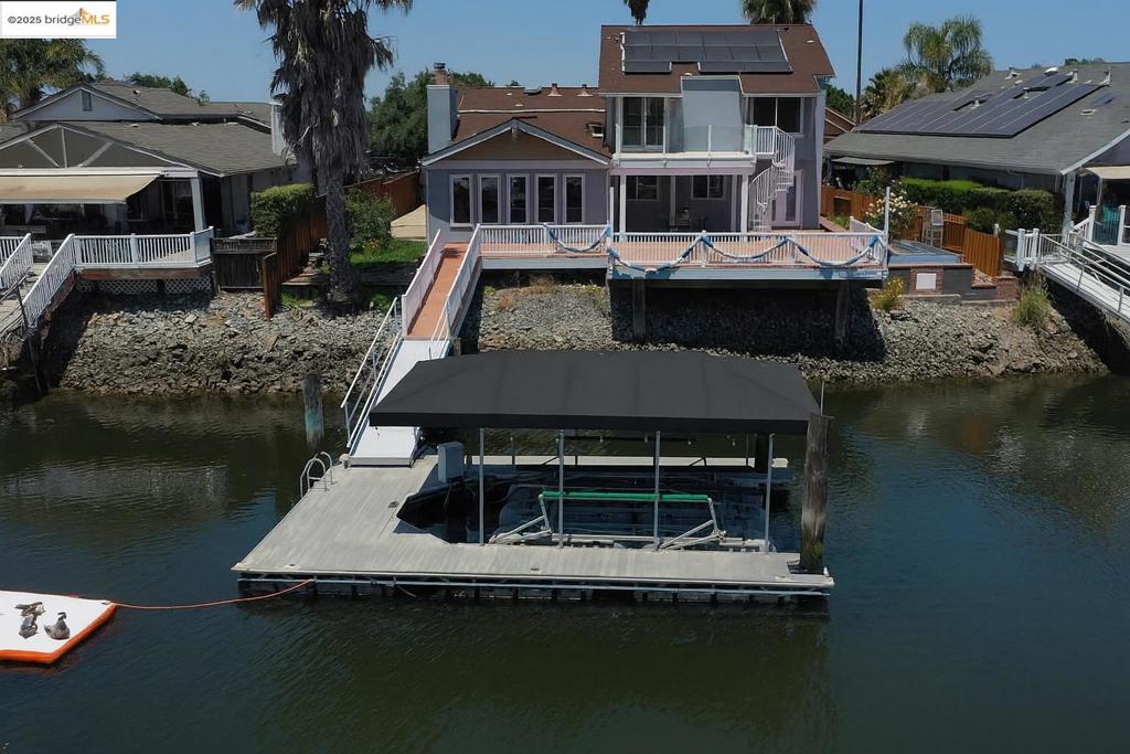 Beautiful remodeled waterfront home in a PRIME location with OWNED SOLAR! This home is just minutes from fast water and the marina, making it ideal for water enthusiasts. The property boasts a private dock and hoist, ensuring easy access to the waterways. The updated kitchen is designed for both functionality and elegance, equipped with modern appliances and finishes that cater to the culinary enthusiast. The bathrooms have been thoughtfully updated, providing a spa-like experience with contemporary fixtures and design. The large primary suite serves as a tranquil retreat, complete with a relaxation area perfect for unwinding after a long day. Step out onto the deck from the primary suite and enjoy the serene views, with a circular stairway leading down to the main deck area. This home is designed for entertaining, offering separate areas that allow for intimate gatherings or larger celebrations. Natural light floods the interior, creating a warm and inviting atmosphere throughout. Off-street and trailer parking provide convenience and ease for residents and guests alike. Long water views enhance the property's appeal, offering a picturesque backdrop for daily living.