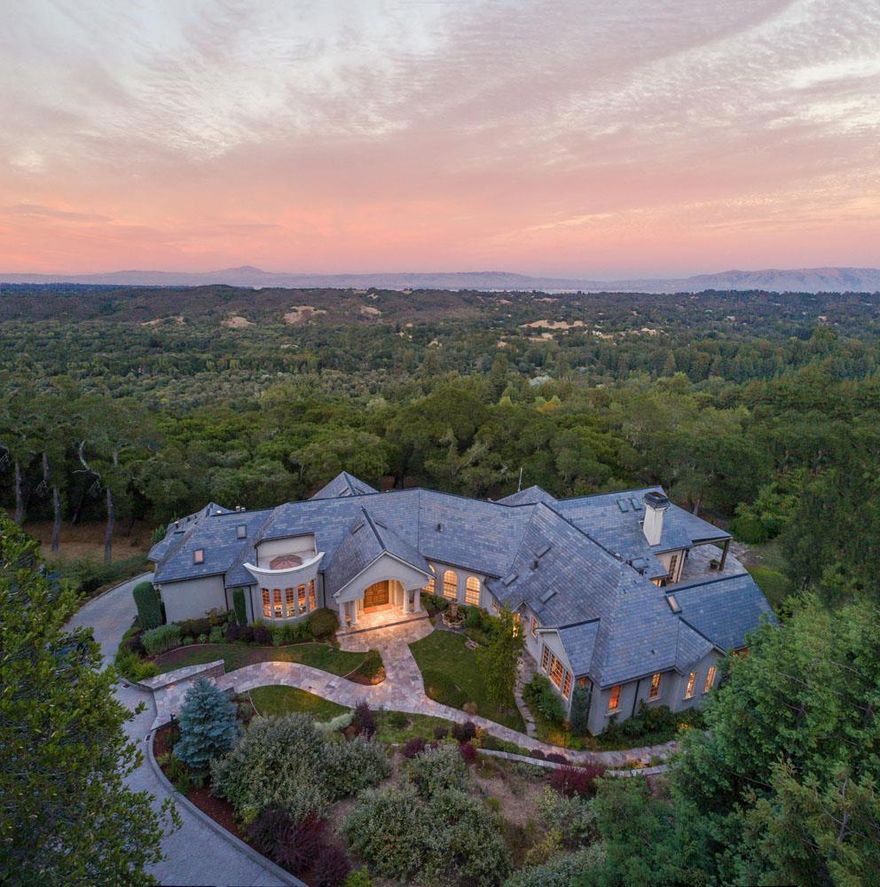 Surrounded in privacy on 7.6 acres, this eco-friendly home was built in 2003 with every luxury in mind, including a theatre, wine cellar, executive office, library, pool, and more. Oriented to magnificent San Francisco Bay views, the close-in country setting is just minutes from Sand Hill Road venture capital centers, Stanford University, and tech centers. Designed for entertaining, the public rooms are grand in scale, the kitchen is outfitted for a professional chef, and more casual living environments are found on both levels of the home, conveniently connected by elevator. There are three spacious bedroom suites plus a fully customized office with Murphy bed and ample space to convert the lower level to extended family quarters, if needed. Indoor/outdoor living is a signature of the home with remote-controlled screens on the loggia, a spacious Bay view deck, sparkling pool, outdoor shower, plus fully fenced vegetable garden and orchards. Highly acclaimed Portola Valley Schools!