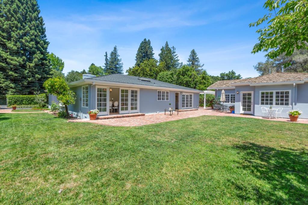 Nestled behind a secure gated entry on a desirable lot in West Atherton, this exquisite single-story home offers a sanctuary of comfort and privacy. With approximately 2,997 sq ft of thoughtfully designed space and meticulously maintained, the home exudes timeless elegance and a multitude of possibilities for the modern professional. Abundant skylights. The spacious living room adjoins the sunny dining room. A separate family room offers great space for everyday living. The primary bedroom invites relaxation with its ensuite full bathroom. Two additional bedrooms, two full bathrooms, plus a convenient office to work from home. Beautifully maintained lawns, trees and shrubs provide a peaceful outdoor haven. A charming, separate guest house awaits, featuring 1 bedroom and full bathroom, kitchenette, laundry area and living room - perfect for hosting colleagues or extended family. Commute with ease to top tech campuses, downtown Menlo Park, and Stanford University.
