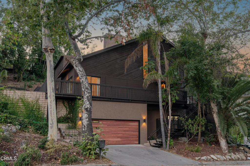 Tucked amongst a canopy of trees in the prestigious San Rafael Hills, 1726 La Loma is a fully renovated estate blending modern elegance, functionality, and resort-style amenities. The design-forward contemporary remodel showcases high-end finishes throughout and adds a touch of sophistication to the day-to-day. Upon entry, soaring ceilings and a striking fireplace set the tone for the home. Expansive sliding glass doors fill the living area with fresh air and natural light, opening to wrap-around balconies, perfect for entertaining. The formal dining room offers generous space for hosting, while the gourmet chef's kitchen stuns with an oversized quartz island, top-tier appliances, and abundant storage. A laundry room and guest bath complete the main level. The lower levels feature three serene bedrooms - ideal for guests, a home office, or studio. From the main living room, floating stairs lead to the spectacular primary suite, preceded by its own lounge. Double doors reveal lofty ceilings, a private balcony with mountain views, a cozy fireplace, and walls of light-filled windows. The spa-inspired bath boasts a jetted soaking tub, walk-in shower, dual vanities, and a spacious walk-in closet. Outdoors, you will enjoy a sparkling pool and spa on the west end and a secluded courtyard on the east, the ideal setting for entertaining or simply enjoying a cup of coffee in the morning. Do not miss this rare Pasadena retreat! Refined, inviting, and unforgettable.