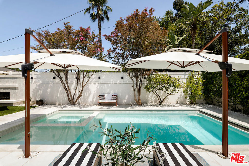 If you've been searching for the perfect blend of dreamy indoor-outdoor living in a quiet, family-friendly neighborhood, this stunning Toluca Woods home will steal your heart. This single-story, thoughtfully designed 4-bedroom, 3-bathroom home is full of character and charm, with designer finishes throughout. Set on an expansive 8,000 sq ft corner lot, the property offers a sprawling outdoor space ideal for relaxing, entertaining, and soaking up the Southern California sunshine or hiding in the shade of the stunning mature olive tree. Over the past few years, the home has been meticulously renovated, including three new bathrooms, a beautifully updated kitchen, wide-plank hardwood floors, new pool and spa, new turf, and newer roof, HVAC, water heater, copper plumbing and is set up with cameras and security system. The vaulted-ceiling living room opens seamlessly to the backyard, creating the feeling of a private resort. Outside, you'll find multiple seating areas, a cozy outdoor fireplace and fire-pit, a dining area with built-in gas line, and a sparkling pool and spa adorned with high-end Zellige tiles and automated pool cover. On the other side of the property, a spacious park-like lawn offers endless possibilities - from play space to a potential sports court. A detached two-car garage adds even more flexibility, whether for parking, storage, or a future bonus space conversion. Toluca Woods is one of Los Angeles' hidden gems - a charming pocket next to Toluca Lake, within close proximity to the beloved shops of Magnolia Park and the dining destinations along Riverside Drive. Each holiday season, the magical neighborhood Christmas Parade even passes right in front of the property! Don't miss your opportunity to own this truly special home.