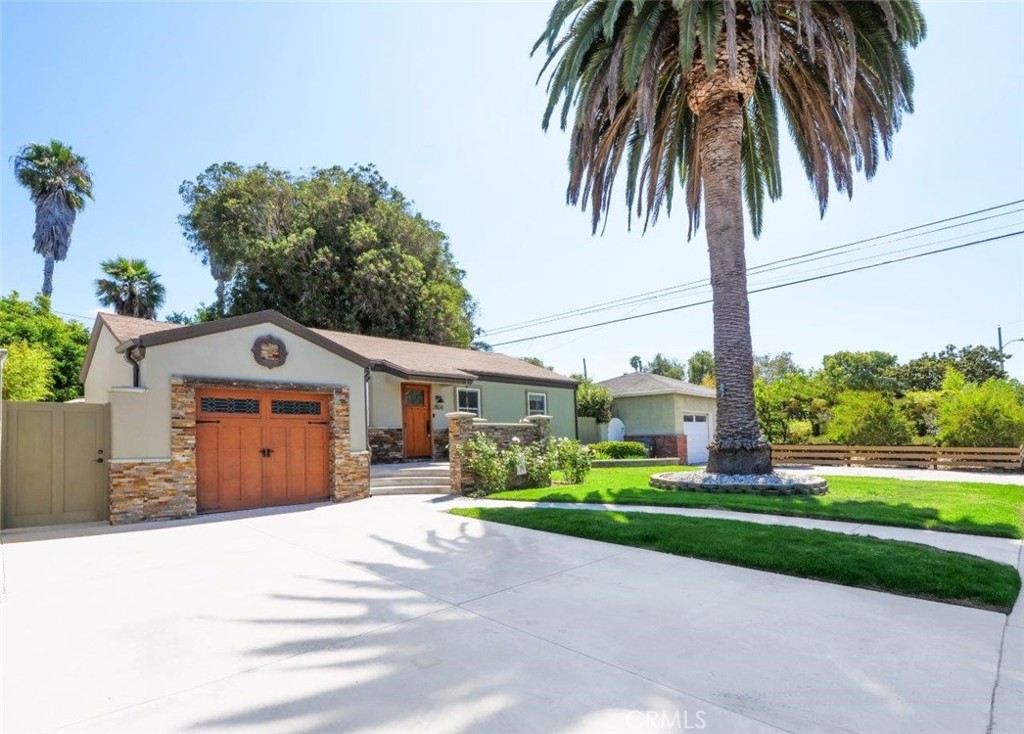Step into this charming home featuring soaring ceilings and gorgeous hardwood floors throughout. Stay comfortable year-round with air conditioning and Milgard double-pane windows that fill the home with natural light. The updated kitchen is a chef’s dream, boasting granite counters, custom soft-close cabinetry, a pot-filler, and premium appliances including a Bosch dishwasher, LG refrigerator, newer stove, and microwave. Skylights in both the kitchen and bathroom add extra brightness. Dual glass doors open to a private backyard oasis with mature trees, a built-in grill, and a dining area—perfect for California indoor-outdoor living. Bedrooms are appointed with Hunter fans, blackout blinds, and custom closets with beveled glass. The bathroom features an antique vanity, bidet, dual showerheads, and beautiful slate walls with tiled flooring. Additional highlights include cherry wood interior doors, LED lighting throughout, and a garage with washer/dryer hookups, sink, cabinetry, and an automatic roll-up door.
