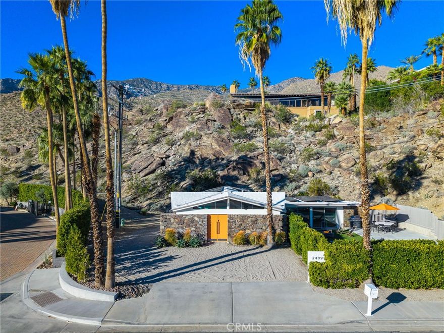 Welcome to a unique and notable Indian Canyons' Mid-Century modern retreat with a notable AirBnb history.  This fully furnished desert escape offers privacy, history, and undeniable Palm Springs style. Rumored to be the original clubhouse for Canyon View Estates, this architectural gem sits on an approximately 18,000 sq ft lot at the base of the mountain, delivering breathtaking hillside and mountain views with true resort vibes.
The home’s dramatic 8-beamed umbrella ceiling and clerestory windows flood the great room with natural light, creating a striking yet relaxed atmosphere, perfect for entertaining or unwinding. 
The updated kitchen and dining area open to a impressive private backyard oasis tucked against the hillside, complete with pool, spa, shaded gazebo, gas firepit, and lush palms—ideal for sunset gatherings and starry nights.  The primary suite is a peaceful retreat with hillside views, a walk-in closet, and ensuite bath, while the guest bedroom enjoys access to a spa-inspired bathroom featuring a substantial walk-in shower and picture window capturing the surrounding desert landscape.
Offered fully furnished and turnkey, this home is thoughtfully equipped with luxury-comfort beds, smart TVs, in-house laundry, a fully stocked kitchen  flexible workspace options, solar blinds, blackout curtains, and abundant private parking. Energy-efficient living is enhanced by 32 OWNED solar panels and a 10kWh battery, significantly offsetting electricity costs. The land lease has been renewed and does not expire until 2080!
Just minutes from downtown Palm Springs, Murray Canyon hiking trails, and the new Palm Springs Surf Club, this one-of-a-kind residence blends architectural significance with modern comfort—offering a lifestyle as unforgettable as the setting.