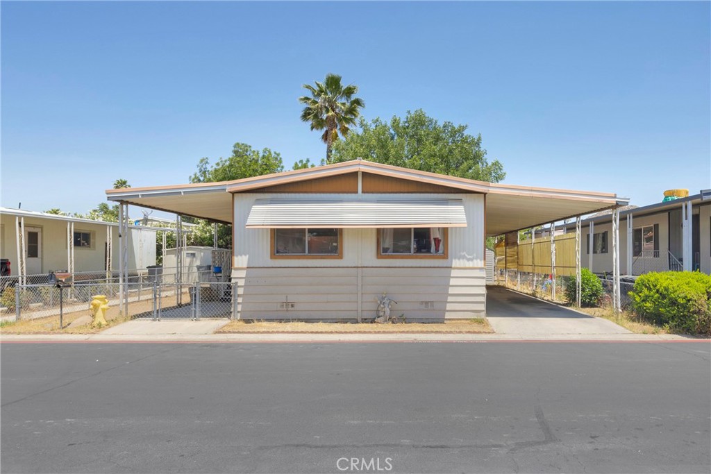 This turn-key beauty is a true gem! Spacious, elegant, and ready for you to move right in—this double-wide manufactured home with a detached garage is a rare find. Step inside and be wowed by the soaring ceilings and open layout—ideal for entertaining! The new laminate flooring throughout sets the stage for a clean, modern feel. The floor plan is brilliant: a generous primary bedroom with its en suite bathroom. The open concept kitchen flows into the dining area, and the huge living room makes this home an entertainer’s paradise. Imagine hosting a party with people—whether it’s on the spacious porch, in the living room, out in the yard, there’s plenty of room for everyone! Located in one of the most quiet communities in Hemet, you'll have access to two sparkling pools, a spa, clubhouse, gym, and a wide range of social activities. It’s not just a home—it’s a lifestyle! Plus, you're just minutes away from shopping, restaurants, and medical offices. Schedule your showing today and see what makes this place so special!
