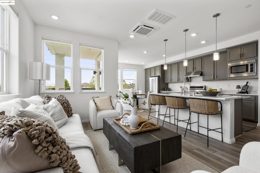 Welcome to your private retreat in the sought-after Bay 37 community, perfectly positioned along Alameda's picturesque West End waterfront. This stylish, single-level corner unit offers 2 bedrooms and 2 baths, blending modern architecture with sleek, contemporary finishes. Built just three years ago, it's bathed in natural light from its desirable south-facing orientation with minimal obstruction privacy & energy efficiency. The airy, open-concept layout features bedrooms thoughtfully separated for maximum privacy. The gourmet kitchen boasts a generous central island-perfect for casual meals or hosting-while the adjacent dining area opens to a private deck. Both bedrooms are spacious with excellent closet storage, and the home comes with thoughtful upgrades including in-unit laundry, air conditioning, owned solar panels, and a two-car tandem private garage prepped for EV charging. Enjoy the convenience of an elevator-served building with bike storage and a rooftop deck. Bay 37 offers waterfront views, picnic areas, a playground, scenic walking paths along the estuary, and a water shuttle to Jack London Square. Alameda Landing's shops, fitness center, and grocery store are just blocks away. This home delivers the perfect balance of modern comfort and prime location.