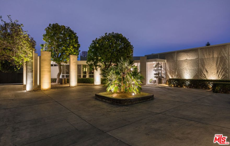 "The Skouras Residence". Behind gates with expansive motor court and beautiful views. Classic 1956 Harold Levitt is timeless and in impeccable condition. The antithesis of the proliferation of modern boxes currently flooding Trousdale. On a large 39+k lot. The entry is flooded with light from the high ceilings and opens to the living room, bar, lanai and game room plus a large dining room opening to a special outdoor dining area. The music room leads into the book-shelved library. The magnificent kitchen and butler's pantry are stainless steel and generous from cooking to storage. The kitchen opens to a family room with large screen TV. Left of the entry are three bedrooms with baths (one is now a gym). To the right is the sumptuous master bedroom, with separate his/hers baths, looking out to a fountain and the view beyond. A sunny pool, lounge area, and bar and BBQ offer private swimming and sunning areas. Off the living room is a wonderful sitting area with an outdoor fireplace.