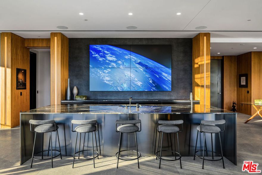 This ultra-luxe Beverly West Penthouse is filled with top-of-the-world elegance and drama. Amazing sight lines emphasize majestic wraparound 360 jet-liner views, exquisite materials, and an open-concept layout that invites memorable entertaining and a lifestyle of unreserved comfort. Light-filled rooms show off flawless finishes and art gallery walls, while bespoke built-ins, including a glass-front wine vault, redefine the word luxury living. A truly spectacular great room extends the home's full width on one side, with formal and informal seating, two balconies, a dining area, and a dramatic bar that features a huge four-screen TV wall installation. Whether the chef is on staff or in residence, the kitchen will meet their most exacting requirements. The four-bedroom suites provide exceptional privacy. The primary suite and junior suite each have a balcony and a lavish spa-style bath. Additional features include an espresso bar, two powder rooms, a spacious gym with a mirrored wall, and an ever-changing panorama of views from floor-to-ceiling windows. The approximately 8,000 square foot residence occupies a full floor of the prestigious Wilshire Corridor high-rise, with direct-access dual private elevators and a full range of luxurious amenities, including valet parking, doorman, fitness center, saltwater pool, conference center, and much more.