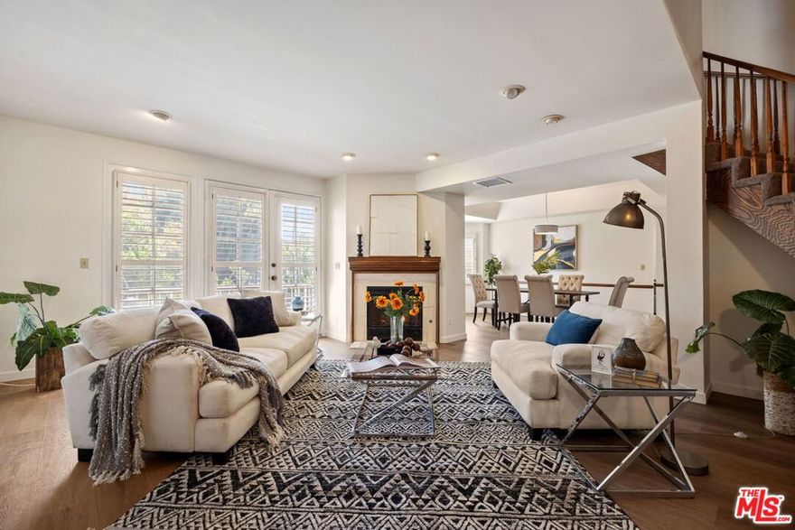 Welcome to this beautifully updated over 2,200 sqft townhome in the heart of Tarzana, offering comfort, style, and convenience in a secure gated community. Set inside a Cape Cod-style community, this residence makes a striking first impression with its charming architectural details and lush landscaping. Inside, you'll find updated interiors with brand-new vinyl flooring that flows seamlessly throughout the main living spaces. The inviting living room features a cozy fireplace, recessed lighting, and a cascading staircase, creating an ideal setting for both everyday living and entertaining. The adjacent dining area is bathed in natural light from the bay windows, while the spacious kitchen offers abundant cabinetry, tile counters, a center island, and a convenient pass-through. A wet bar and powder room on the main level add to the home's functionality. Upstairs, the expansive primary suite serves as a true retreat, complete with a walk-in closet and an ensuite bath featuring dual sinks, a soaking tub, and a separate shower. Two additional bedrooms are generously sized with ample closet space, accompanied by another full bathroom with dual vanities. A versatile bonus room provides the perfect space for a home office, media room, or guest quarters. Additional highlights include plantation shutters, in-unit laundry, and direct access to a private 2-car garage. The well-maintained community offers a tranquil environment while being just minutes from Tarzana's and Encino's best shopping, dining, schools, and freeway access.