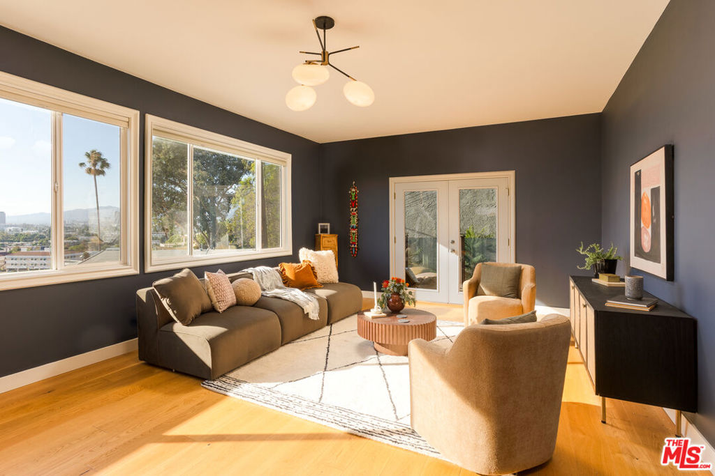 On the slope of Adams Hill, where the city stretches below and sky opens above, this meticulously renewed home is designed to catch the light at every hour. Morning begins through wide picture windows, rising across European oak floors; evenings settle by the fireplace as the city below flickers to life. The entry, with its tall ceilings and double doors, gives way to a living space both open and composed. The kitchen is deliberate in its choices- Bosch appliances, induction cooktop, terrazzo floors, Cambria quartz counters- streamlined and sunlit. Just beyond, the dining room opens to the balcony, a natural pause where meals stretch longer with mountain views in the distance. Upstairs, the primary suite carries its own hearth, an understated gesture that anchors the room. The en suite bath is clean-lined and quiet in terrazzo, while two additional bedrooms share the light, each with thoughtful detailing. Bathrooms across the home echo the same care- custom cabinetry, Toto bidets, considered finishes. The home's rhythm extends to its quieter corners: a main-floor bedroom with balcony doors thrown open, a finished basement ready to flex into a studio, office, or gym. Outside, a pergola shades a quiet lounge area, conversation lingering as the neighborhood hum fades to calm. Beneath the design, every system has been renewed with intention: energy-efficient roof, dual-zone HVAC with heat pump, upgraded 220v electrical circuits. A structure as thoughtful as its spaces. Moments from Adams Square and the vibrancy along Verdugo Boulevard, this is a home with outlook and grounding city lights in view, a sense of retreat at hand.