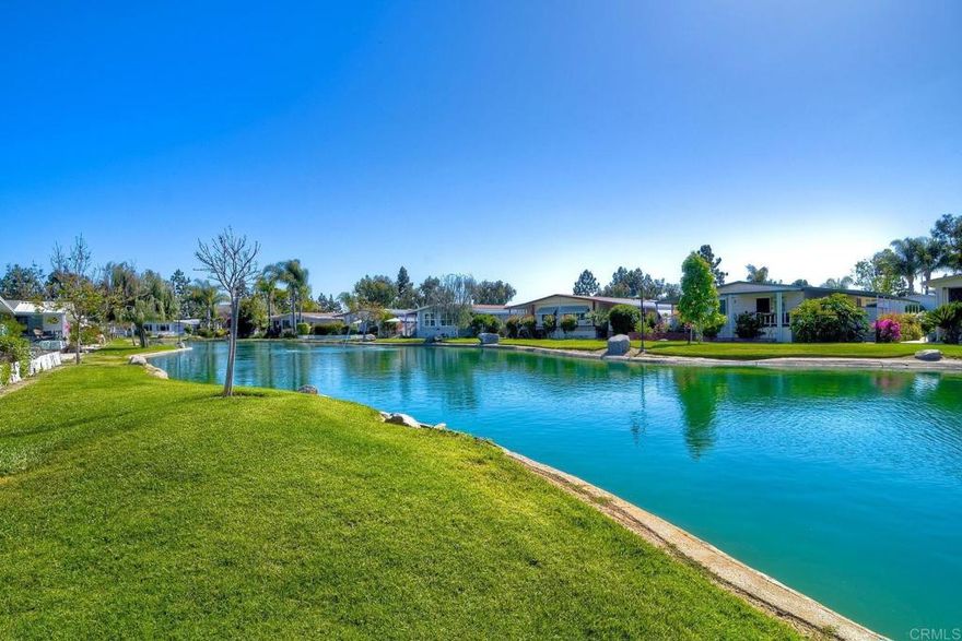 Home has a  stunning lake and green belt  view. There is a Large deck for relaxing with water view.   Features an open floor plan that entertains a feeling that you are in a resort.  Large picture windows.  Kitchen opens to a dining room that leads to a large living space. Bathrooms have been updated and home throughout is same,  with convenience and  peaceful living space.  Updated paint and wonderful decor thru out. One year old washer and dryer This is a must see in a senior park called Laguna Vista Mobile Home Estates where nature abounds .  A gated community located close to freeway, shopping. Beach is to the west by freeway.  The complex has a parklike setting with lakes thruout. Shed in Carport and pleasant sitting arrangement.