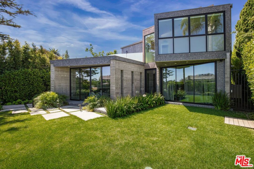 Modern masterpiece located on one of the most coveted streets in Santa Monica. Beyond the gated entry and lush front yard, enter the home to experience the perfect blend of design and function. A combination of exposed board-formed concrete, French limestone and beautiful white oak cabinetry and floors deliver sophistication and understated elegance. Anchoring this architectural marvel designed and built by Kevin McCauley is a custom, one-of-a-kind staircase that is truly a work of art. Crafted for indoor/outdoor entertaining, the kitchen and family room's sliding glass doors open to additional dining areas and a resort-like pool. The pool, with its cascading waterfalls and hot tub, is perfect for swimming laps or simply relaxing. Rounding out the main level is a formal living room, dining area, home office, bedroom, and powder room. An elevator accesses all levels of the home. The second level is comprised of three spacious ensuite bedrooms including the primary, comfortable lounge/family room area, large laundry room and access to the rooftop deck. Unwind in the luxurious primary suite with spa-like bathroom lined in beautiful marble, dual walk-in closets, wet-bar, and private patio. A spacious lower level features a rec room, full bar, exercise area, theatre, bedroom, laundry and a number of storage rooms. The detached guest house is a fully outfitted one-bedroom guest quarters or office with living area, kitchen, bathroom, and separate entrance. The impeccable location is a short stroll to Montana Ave's shops, restaurants, and the glistening Pacific Ocean.
