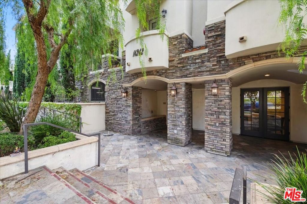 Welcome to 14242 Burbank Blvd #103 a beautifully designed luxury condo tucked away from the busy street, offering privacy and comfort in the heart of Sherman Oaks. Welcome inside to an open-concept floor plan filled with natural light. The spacious living room flows seamlessly into the dining area and modern kitchen, perfect for both everyday living and entertaining. Gorgeous wood flooring runs throughout the home, adding warmth and sophistication. The kitchen boasts granite countertops, a stylish breakfast bar, and ample cabinetry, making it both functional and inviting. Two generously sized bedrooms sit on opposite sides of the unit for ultimate privacy. The primary suite features a spa-like bathroom with dual sinks, a large walk-in shower, and a separate Jacuzzi tub for relaxation. Additional features include recessed lighting, an in-unit washer and dryer, a private balcony ideal for morning coffee or evening unwinding, and a cozy fireplace for those chilly nights. The building offers fantastic amenities, including a rooftop patio with stunning 360-degree mountain and tree views, a recreation room with pool and game tables, a fitness area, guest parking, and two dedicated gated parking spaces. Conveniently located near Westfield Fashion Square, local restaurants, and with easy access to the 101 and 405 freeways, this 2007-built condo is truly a gem. Elevator access included. Don't miss this incredible opportunity to call Sherman Oaks home!