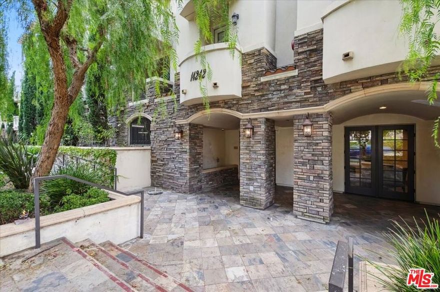 Welcome to 14242 Burbank Blvd #103  a beautifully designed luxury condo tucked away from the busy street, offering privacy and comfort in the heart of Sherman Oaks. Welcome inside to an open-concept floor plan filled with natural light. The spacious living room flows seamlessly into the dining area and modern kitchen, perfect for both everyday living and entertaining. Gorgeous wood flooring runs throughout the home, adding warmth and sophistication. The kitchen boasts granite countertops, a stylish breakfast bar, and ample cabinetry, making it both functional and inviting. Two generously sized bedrooms sit on opposite sides of the unit for ultimate privacy. The primary suite features a spa-like bathroom with dual sinks, a large walk-in shower, and a separate Jacuzzi tub for relaxation. Additional features include recessed lighting, an in-unit washer and dryer, a private balcony ideal for morning coffee or evening unwinding, and a cozy fireplace for those chilly nights. The building offers fantastic amenities, including a rooftop patio with stunning 360-degree mountain and tree views, a recreation room with pool and game tables, a fitness area, guest parking, and two dedicated gated parking spaces. Conveniently located near Westfield Fashion Square, local restaurants, and with easy access to the 101 and 405 freeways, this 2007-built condo is truly a gem. Elevator access included. Don't miss this incredible opportunity to call Sherman Oaks home!