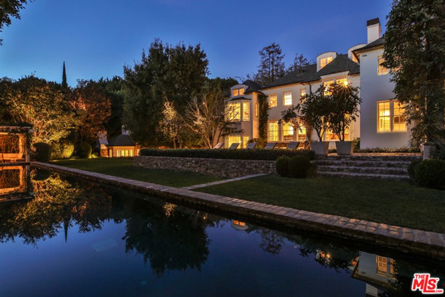 Impeccable Bel Air estate originally built by renowned architect Paul R. Williams & designed by Sandy Gallin & architect Scott Mitchell. The gated home includes wood beamed ceilings, bay window seats & hardwood floors throughout. The main level, w/winding staircase entry, offers a fplc library, formal dining & breakfast rm, gourmet island kitchen, fplc formal living rm that flows into a family rm w/triple French doors to an outdoor dining area, & fplc lanai w/views & access to a landscaped backyard, 110' pool, trellis sitting area, BBQ, & pizza oven. The upper level offers an owner's retreat w/2 luxe baths, substantial closet spaces, & stairs to a loft-style office w/ocean view deck, plus 3-add'l bdrms. The lower level includes a media rm w/triple French doors that open to the sounds of a cascading waterfall patio, fplc bonus rm w/climate controlled wine rm, gym w/fplc sitting area plus 2-add'l bdrms. A detached 3-car garage has a 2nd level guest rm w/wood deck & views of downtown LA.