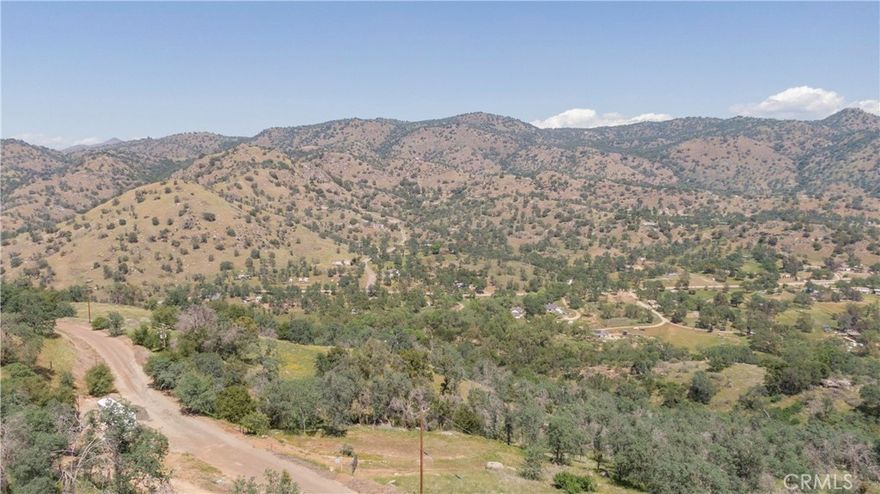 Private 4.75+- acre lot with stunning mountain views on a low traffic road. This property is studded with mature oak trees and unique rock outcroppings. Improvements include a driveway, recently enlarged building pad, retaining wall and septic system, and as per seller, access to water.
Beyond the current leveled area, the property meanders down to a large open and level area that would also make an excellent homesite, shop area,
 orchard... The location around the corner from the Country Store & about 15 minutes to HWY 180 or Orange Cove. Great water in the area. Come see it while it lasts!