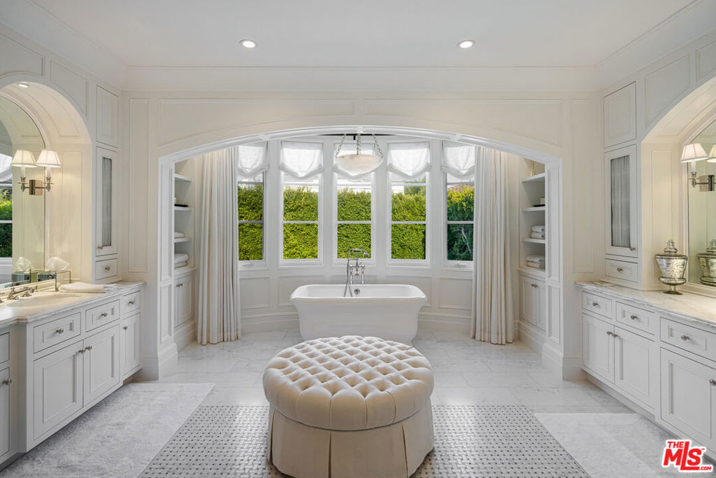 Experience timeless elegance and modern sophistication at this Brentwood estate offering 5 bedrooms, 6 bathrooms, and a seamless blend of luxury and comfort. Nestled on a serene, tree-lined street, this beautifully crafted home is a true retreat. The grand entry showcases a spiral staircase and rich hardwood floors, while natural light floods every corner. The gourmet kitchen, complete with a Wolf range, Sub-Zero refrigerator, marble countertops, and a spacious island, opens effortlessly to the family room and lush backyard. The formal dining room, adorned with a dazzling chandelier, creates a perfect setting for memorable gatherings. The primary suite serves as a private sanctuary with a spa-inspired bath, soaking tub, walk-in closet, and tranquil views. Each additional bedroom is thoughtfully designed for comfort and style. A dedicated office/library and fitness room offer added flexibility. Step outside to your private oasis, featuring manicured gardens, a sparkling pool, and a fully equipped outdoor kitchen for entertaining. Located just minutes from Brentwood's best shopping and dining, this home is the epitome of luxury and convenience.