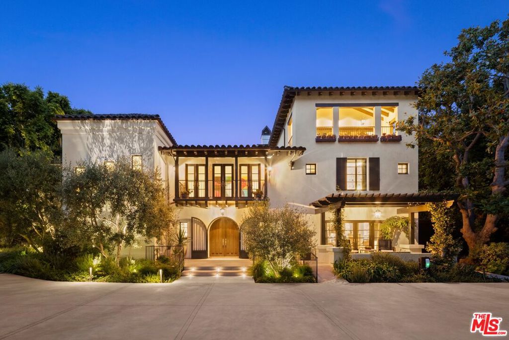 Privately gated on one of Brentwood Park's most prestigious streets, this exceptional estate offers over 9,500 sq ft of thoughtfully designed living on a lush .59-acre lot. Timeless architecture blends seamlessly with warm, functional interiors, creating a true sanctuary for elegant entertaining and elevated family living. Dramatic volume and natural light fill the home, with soaring ceilings reaching over 20 feet in the kitchen and family room. A private elevator enhances convenience across all levels. Upstairs, a luxurious primary suite with fireplace, sitting room, and dual walk-in closets is complemented by three generous secondary bedrooms and a spacious playroom. At the heart of the home is a stunning chef's kitchen with top-tier appliances, oversized island, and walk-in butler's pantry opening to a sunlit great room with effortless indoor-outdoor flow. Additional highlights include a formal dining room, private office, full gym, Pilates/dance studio, and separate staff quarters. The resort-like grounds are designed for both vibrant entertaining and tranquil retreat, featuring a swimmers' pool and spa, championship pickleball/sport court, basketball hoop, putting green, and a covered outdoor kitchen with BBQ pavilion. Wellness amenities include an inviting outdoor shower, private sauna, and rejuvenating cold plunge. Meandering garden paths, hidden sitting areas, and a curated farm-to-table vegetable garden create serene moments throughout, while a large grassy lawn offers ample space for kids and pets. Completing the estate is a fully detached guest house with living room, kitchenette, full bath, and private bedroom, ideal for guests, staff, or extended family. An unparalleled offering of luxury, privacy, and lifestyle in Brentwood's most coveted enclave just moments from the Brentwood Country Mart, top-rated schools, and all the best of the Westside.