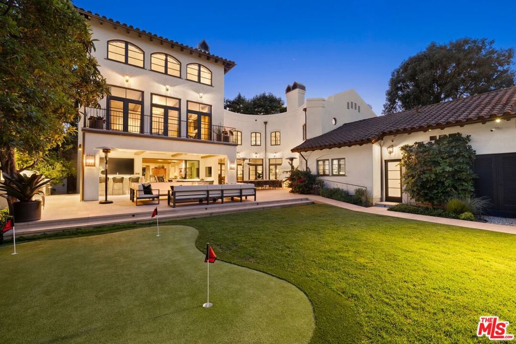 Privately gated on one of Brentwood Park's most prestigious streets, this exceptional estate offers over 9,500 sq ft of thoughtfully designed living on a lush .59-acre lot. Timeless architecture blends seamlessly with warm, functional interiors, creating a true sanctuary for elegant entertaining and elevated family living. Dramatic volume and natural light fill the home, with soaring ceilings reaching over 20 feet in the kitchen and family room. A private elevator enhances convenience across all levels. Upstairs, a luxurious primary suite with fireplace, sitting room, and dual walk-in closets is complemented by three generous secondary bedrooms and a spacious playroom. At the heart of the home is a stunning chef's kitchen with top-tier appliances, oversized island, and walk-in butler's pantry opening to a sunlit great room with effortless indoor-outdoor flow. Additional highlights include a formal dining room, private office, full gym, Pilates/dance studio, and separate staff quarters. The resort-like grounds are designed for both vibrant entertaining and tranquil retreat, featuring a swimmers' pool and spa, championship pickleball/sport court, basketball hoop, putting green, and a covered outdoor kitchen with BBQ pavilion. Wellness amenities include an inviting outdoor shower, private sauna, and rejuvenating cold plunge. Meandering garden paths, hidden sitting areas, and a curated farm-to-table vegetable garden create serene moments throughout, while a large grassy lawn offers ample space for kids and pets. Completing the estate is a fully detached guest house with living room, kitchenette, full bath, and private bedroom, ideal for guests, staff, or extended family. An unparalleled offering of luxury, privacy, and lifestyle in Brentwood's most coveted enclave just moments from the Brentwood Country Mart, top-rated schools, and all the best of the Westside.