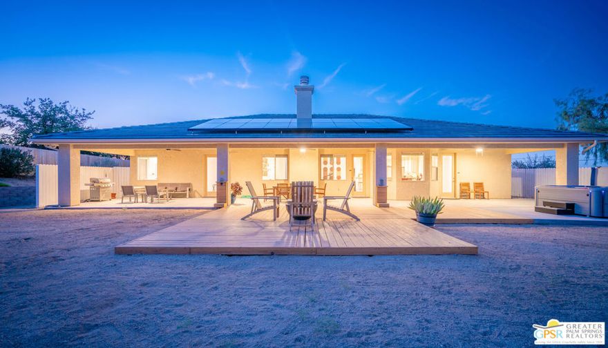 Unbeatable value in the heart of Joshua Tree! This enchanting 4-bedroom, 3-bathroom home sits on nearly an acre, blending timeless architecture with modern amenities for an unparalleled living experience. Recently renovated, this gorgeous property boasts high ceilings and an open-concept design, creating an inviting and spacious atmosphere. This is your dream retreat in the serene neighborhood of Upper Friendly Hills! Enjoy living in one of the best located neighborhoods in Joshua Tree, situated just a few blocks from the village and town center, you'll enjoy the convenience of local shops and dining while being only 10 minutes from the breathtaking landscapes of Joshua Tree National Park, perfect for exploring serene hiking trails and awe-inspiring natural beauty. Step into your private backyard sanctuary, where lush landscaping and a spacious covered patio set the stage for outdoor entertaining. Unwind on the brand-new deck with a hot tub, or cozy up by the firepit on cool desert evenings. Inside, a beautifully remodeled ensuite bathroom features modern fixtures, LED lighting, and thoughtfully placed switches for added convenience. Additional upgrades including epoxy-painted cabinets and floors, powered blinds, dual Navien tankless water heaters, house fully vented for a swamp cooler, and a propane-plumbed fire pit and barbecue enhance both style and functionality. Security and comfort are top priorities, with a SimpliSafe alarm system, Ring security cameras, and video doorbells ensuring peace of mind. A gated entry leads to a spacious 3-car garage with EV charging and RV access, offering ample storage for all your recreational gear. Plus, with 20 solar panels on a transferable lease, this home is as eco-friendly as it is luxurious. Perfectly suited for short-term rentals, this home offers a lucrative opportunity for investors or those seeking a hassle-free Airbnb experience. Furnishings are negotiable! Providing meticulous attention to detail and a host of amenities designed to impress, this gem is ready to welcome you home to the enchanting beauty of Joshua Tree.  Whether you are looking for a primary residence, vacation getaway, or short-term rental investment, this beautifully designed property offers a seamless blend of comfort, style, and opportunity. Don't miss your chance to own a slice of desert paradise schedule a showing today!