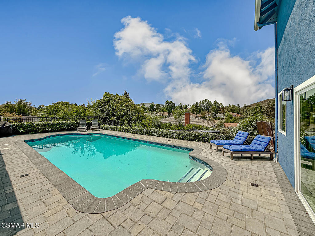 EXPANDED Santa Barbara Model on CUL-DE-SAC with POOL & VIEWS! Located in the serene neighborhood of Conejo Hills of Thousand Oaks, this fantastic home boasts a HANDSOME curb appeal enhanced by its brick-surfaced front patio, sprawling grass lawn, and EXTRA wide + brick-ribboned driveway. Inside, you are greeted by UPGRADED wood flooring, dual-paned windows, myriad recessed lights, and scraped ceilings found THROUGHOUT the bright home. The Living Room to your left enjoys TALL ceilings and is anchored by a BEAUTIFUL redone gas fireplace which is flanked by attractive built-in cabinetry. Overlooking the Living Room, the Dining Room is a versatile space -- use it for formal Dining, as an at-home office, kids play room, OR remove its right-side wall to expand the Kitchen (re-plumbing & re-wiring is SUPER easy to do with the raised foundation)! The neighboring Kitchen has been given FRESHLY painted cabinetry, ATTRACTIVE granite countertops, stainless-steel appliances including a GAS range, and provides BOTH breakfast bar seating AND an informal dining/breakfast eating area. The Family Room rests adjacent, enjoying its own fireplace + built in cabinetry, and is BRIGHT from tall plantation-shuttered windows to backyard views. The home's LARGE & ADDED Bonus Room is accessed via this Family Room and is a stellar media/movie room, game room, or at-home gym, fitted with an ample dry bar, step-in storage closet, and wall-length set of sliding glass doors to the backyard. A staircase leading from this Bonus Room leads to the two ADDED secondary bedrooms upstairs which are BOTH roomy in size. (Addition offers a possibilty of a conversion into an ADU) Two ADDITIONAL secondary bedrooms upstairs give great family/guest living space, and the Primary Bedroom is a spacious suite which has TWO closets, an upgraded dual-sink vanity, and a separate water room. Back downstairs, a secondary bedroom off the Entry serves as the home's 6th bedroom and it neighbors the downstairs 3/4 bath to provide full downstairs living. Outside, you are blown away by the OPEN treetop views enjoyed by the sparkling pool and SPRAWLING covered patio - all given awesome PAVER-STONE hardscaping! A SOLAR pool heater AND no cost SOLAR electric system (with 2 Tesla back-up batteries) for the home mean LOW electricity bills for all 4 seasons (including swim season)! At this home, you have WALKABILITY to Los Robles Hospital and access to stellar AWARD-winning schools, with close proximity to the STUPENDOUS Wildwood hiking & biking trails, public tennis courts / soccer fields / playgrounds!