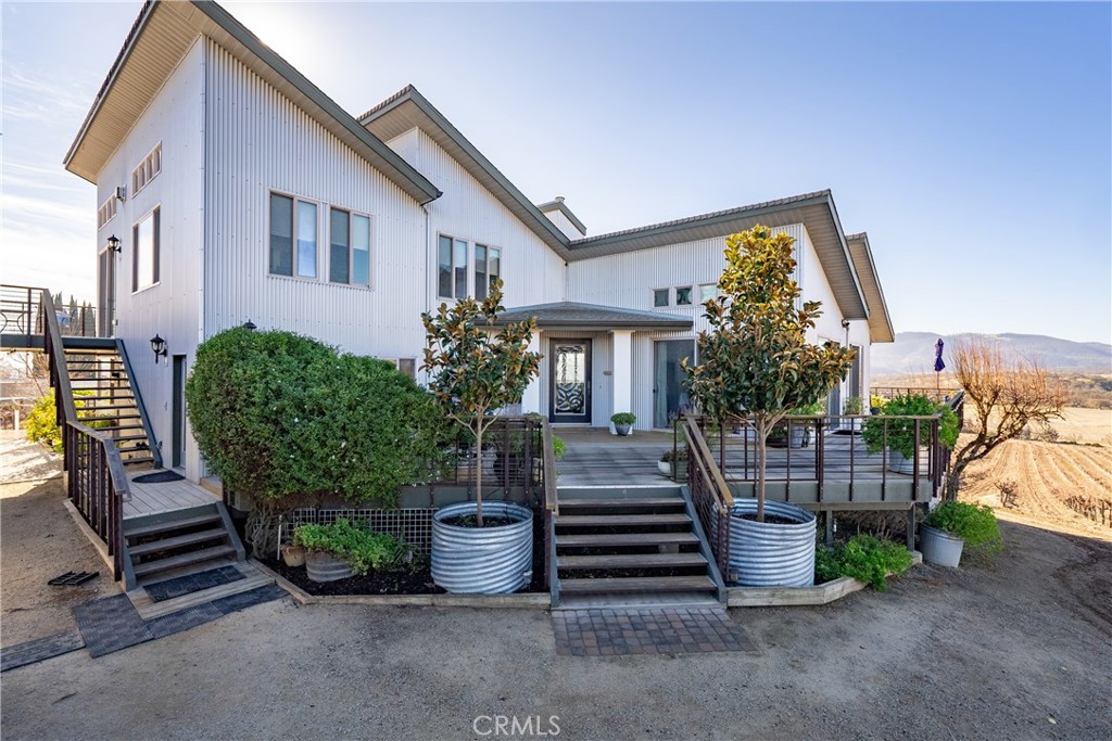 Exceptional investment opportunity on 9± acres in Paso Robles' west side, named the #3 Best Vacation Rental of 2024 by Houfy and generating $110,000+ in annual income. 7.4 acres of thriving vines with an evergreen vineyard lease in place. This contemporary estate blends modern elegance with the timeless beauty of wine country living. Surrounded by panoramic vineyard views and endless rolling hills, the property offers a peaceful retreat from the everyday hustle and bustle. The 3,311± sq. ft. main residence is thoughtfully designed with 4 spacious bedrooms and 4.5 bathrooms, including three en-suites with sunrise-to-sunset views. The primary suite is a tranquil haven, filled with natural light serene vistas and a luxurious Japanese soaking tub. Step outside to a stunning wraparound deck made of Brazilian Ipe wood perfect for morning coffee or sunset wine under painted skies. The gourmet kitchen is a chef’s dream, featuring a commercial-grade Jade range with griddle, sleek quartz countertops, a generous island, and a walk-in pantry. Entertainment and lifestyle amenities abound: a private patio with fire pit and bistro lights, an intimate wine cellar, and a four-car garage/workshop with its own bathroom. Outdoors, enjoy a garden, chicken and 35 mature fruit trees. Fully fenced and gated with Solar, this extraordinary estate offers privacy, passive income, and a front-row seat to the magic of Paso Robles wine country.