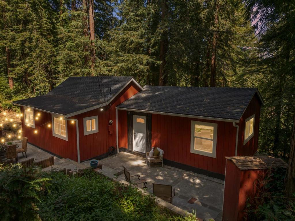 Located on nearly an acre not too far up, this quintessential three-bedroom, one-bathroom mountain home is move-in ready and features an excellent floor plan with the common areas flowing seamlessly from room to room. Modern touches like dual pane windows, interior laundry, and a large farmhouse sink add comfort and function. The spacious kitchen is really the heart of the home providing plenty of countertop to prep meals from a central vantage point. Homesteaders will love the fenced-in garden for growing vegetables and fruits and the chicken coop (aka Fort Chicken) for fresh eggs. A gas stove in the primary bedroom provides warmth both literally and aesthetically. Enjoy relaxing on the patio with guests over a refreshing beverage while enjoying a warm breeze and listening to the gentle sounds of native birds. 5 detached sheds provide ample storage space for tools, equipment, and personal items. Ample parking spread across two driveways off two streets with two other parcels provide convenience and versatility. Meanwhile, outdoor enthusiasts will love the close proximity to one of the hidden gems in San Lorenzo Valley, Loch Lomond Reservoir, which has hiking trails, picnic benchers, fishing, and paddle boats available for rent while being only a short drive to Felton town.