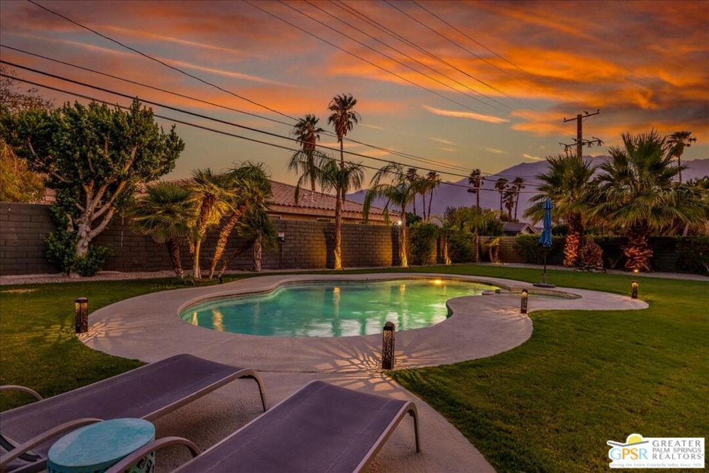 Welcome to your Palm Springs dream retreat! Enjoy spectacular mountain views from your own private poolside oasis at this stylishly updated 3-bedroom, 2-bath home, perfectly situated on a prime oversized lot. The modern exterior boasts a sleek facade with dark accents and striking 16-panel glass garage doors, setting the tone for the chic interiors. A grand double-door entry opens to an impressive foyer with custom geometric tile, making a bold design statement. Inside, you'll find expansive marble tile floors, hand-selected lighting, ceiling fans, and custom window treatments throughout. The airy great room showcases vaulted ceilings, recessed lighting, and a custom fireplace with marble surround, flowing seamlessly into the dining area with its own built-in buffet and statement chandelier. The kitchen is a chef's delight - featuring a quartz-topped peninsula, a mix of rich dark lower cabinets and bright white uppers, stainless steel appliances, floating shelves, and elegant marbled quartz countertops. The spacious primary suite is a serene escape with a designer accent wall, walk-in closet, and a remodeled ensuite with quartz-topped vanity, glass-enclosed shower, and sleek black fixtures. The second suite also offers a walk-in closet and a beautifully updated bath, while the third bedroom is light-filled and versatile, also with its own walk-in. Step outside to a resort-worthy backyard with a freeform pool and spa, surrounded by an expansive covered patio - perfect for dining al fresco or hosting under the desert sky. Just minutes from downtown Palm Springs, you're close to world-class dining, shopping, nightlife, and cultural attractions. Offered fully furnished for an effortless move-in, this home is the perfect blend of style, comfort, and location.
