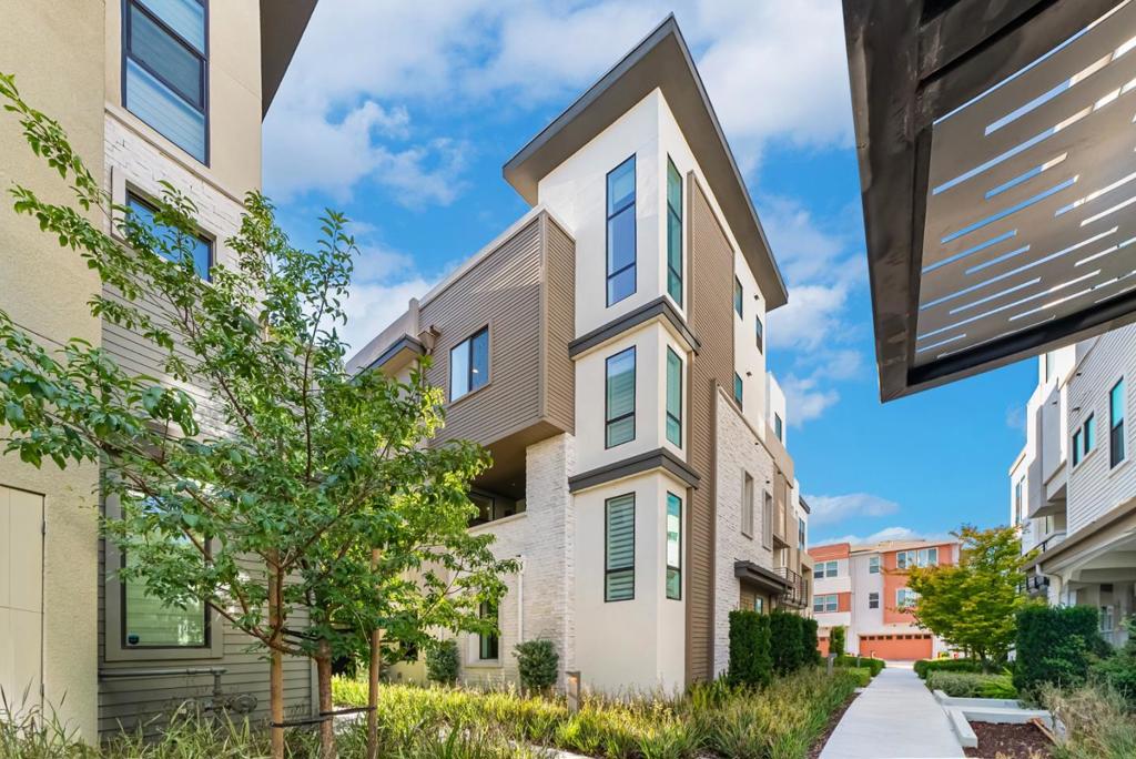 5-yr-old SummerHill Homes CORNER unit townhome in NUEVO,offering modern design,functional space & prime Silicon Valley convenience.This rare floor plan has 4 bedrooms,3 full baths & 2 half baths for comfort & versatility. Only FEW in this community.The open main level is filled with natural light & features a kitchen with large island,white cabinets,quartz counters,backsplash,stainless appliances & ample storage.A ground-floor guest suite is perfect for visitors,extended family or office.Middle-level bedrooms include a primary suite with double vanities & walk-in shower with bench.Upstairs,a family/media room with half bath opens to a rooftop terrace with linear fireplaceideal for gatherings or relaxing nights under the stars.Upgrades include zoned HVAC,tankless water heater & EV charger.Community offers basketball court,playground,outdoor gym,2 dog parks,garden planters,clubhouse,grill & picnic tables.Ideally located minutes to top tech campuses,freeways,Trader Joes,dining,shopping,parks & entertainment venues,with easy access to Caltrain & light rail.Close to vibrant downtown areas,major employers & weekend getaway spots like the coast & wine countryrare chance for low-maintenance living in the heart of Silicon Valleys most desirable & thriving locations.