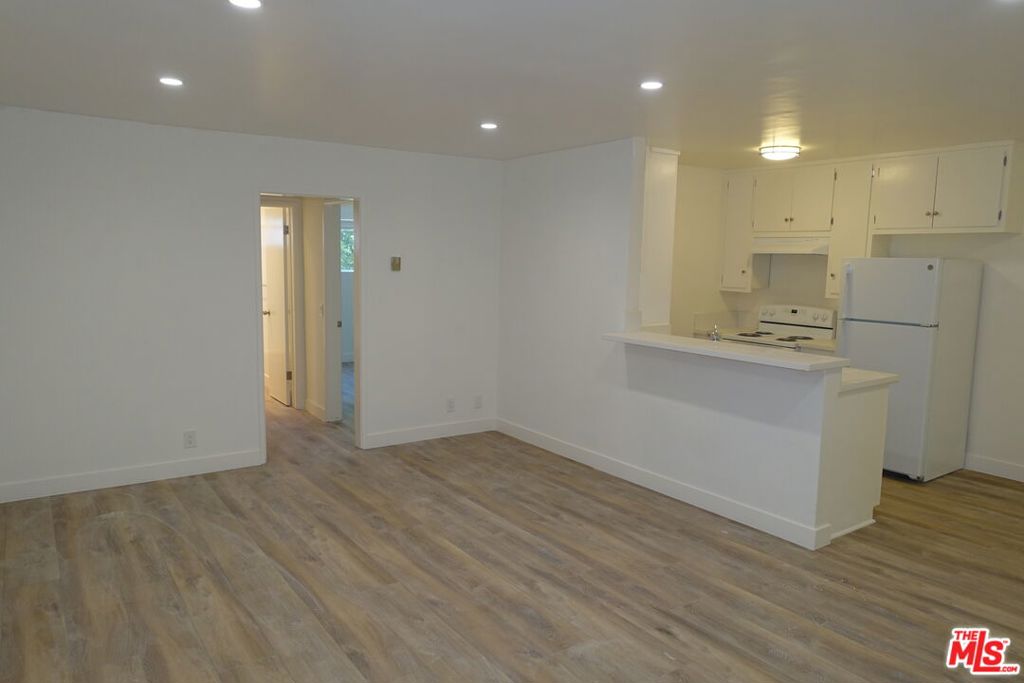 This spacious 1-bedroom residence offers approximately 800 sq ft of comfortable living space in the heart of Hollywood. Designed with an open floor plan, the unit features wood-style flooring throughout, oversized windows that bring in plenty of natural light, and a well-appointed kitchen with a breakfast bar, generous cabinet space, and appliances included. The bathroom is fresh and modern with a full tub/shower combo and updated finishes. Residents will appreciate the secure, well-maintained building along with unbeatable proximity to Runyon Canyon, Hollywood & Highland, major studios, and some of the city's best dining, shopping, and nightlife. A perfect blend of comfort, convenience, and location.