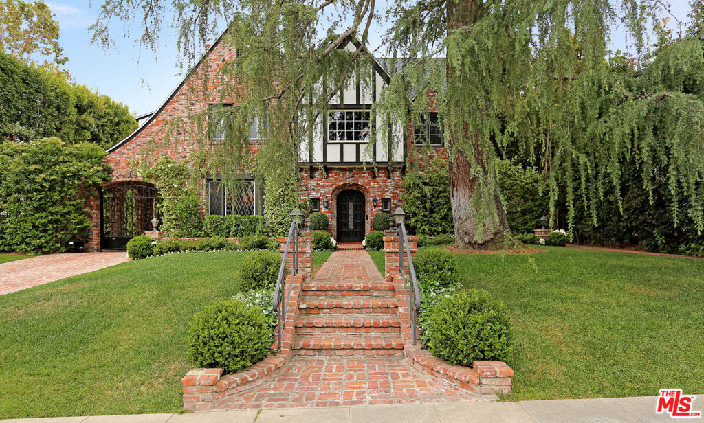 Beautifully redone family Tudor with guest house on an over 14,300 sq. ft. lot in the prestigious flats of Beverly Hills. This impeccably well-maintained home is extremely private and wonderful for entertaining. It features a master suite upstairs with large marble his and hers bath, jacuzzi tub and steam shower, and three walk in closets. Upstairs are two additional bedrooms and baths plus a generous built-in office for two. Downstairs off the center hall floor plan are the gracious formal dining and living room with fireplace, maids quarters and bath, gourmet cook's kitchen with skylight, large open breakfast area and family room/den with fireplace. French doors lead out to spacious terrace and barbecue. This home is surrounded by gorgeously landscaped grounds, with pool, jacuzzi and waterfall, and large two story guest house with kitchen and two baths. Two car garage and a third parking space under the port cochere.Only blocks away from world class shopping, restaurants and theatre.