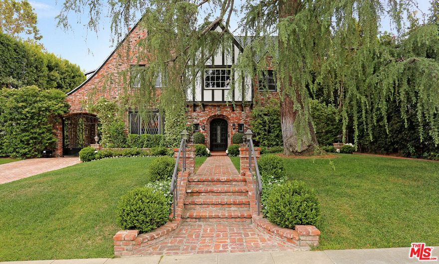 Beautifully redone family Tudor with guest house on an over 14,300 sq. ft. lot in the prestigious flats of Beverly Hills. This impeccably well-maintained home is extremely private and wonderful for entertaining. It features a master suite upstairs with large marble his and hers bath, jacuzzi tub and steam shower, and three walk in closets. Upstairs are two additional bedrooms and baths plus a generous built-in office for two. Downstairs off the center hall floor plan are the gracious formal dining and living room with fireplace, maids quarters and bath, gourmet cook's kitchen with skylight, large open breakfast area and family room/den with fireplace. French doors lead out to spacious terrace and barbecue. This home is surrounded by gorgeously landscaped grounds, with pool, jacuzzi and waterfall, and large two story guest house with kitchen and two baths. Two car garage and a third parking space under the port cochere.Only blocks away from world class shopping, restaurants and theatre.